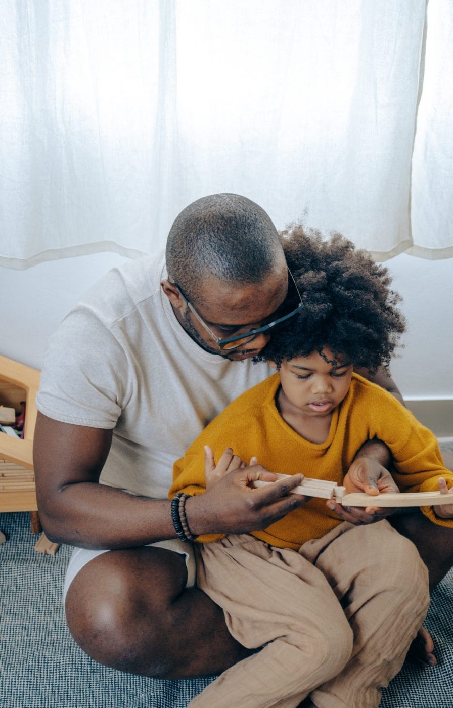 6 simple ways to teach kids emotional intelligence (that you’re probably already doing) dad reading book with child