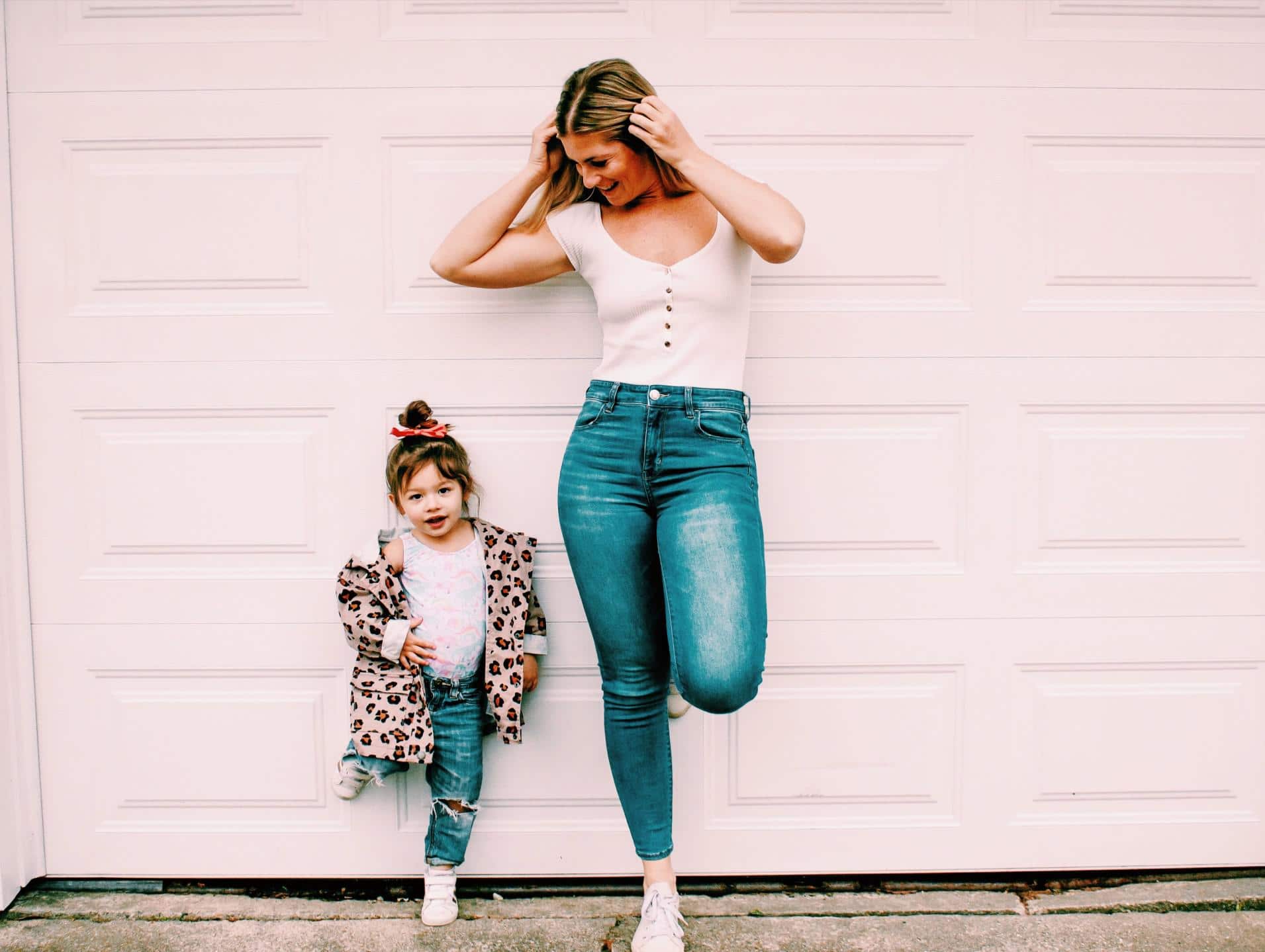 I’m leaning into my ’90s roots during these strange times mom and daughter leaning against a brick wall