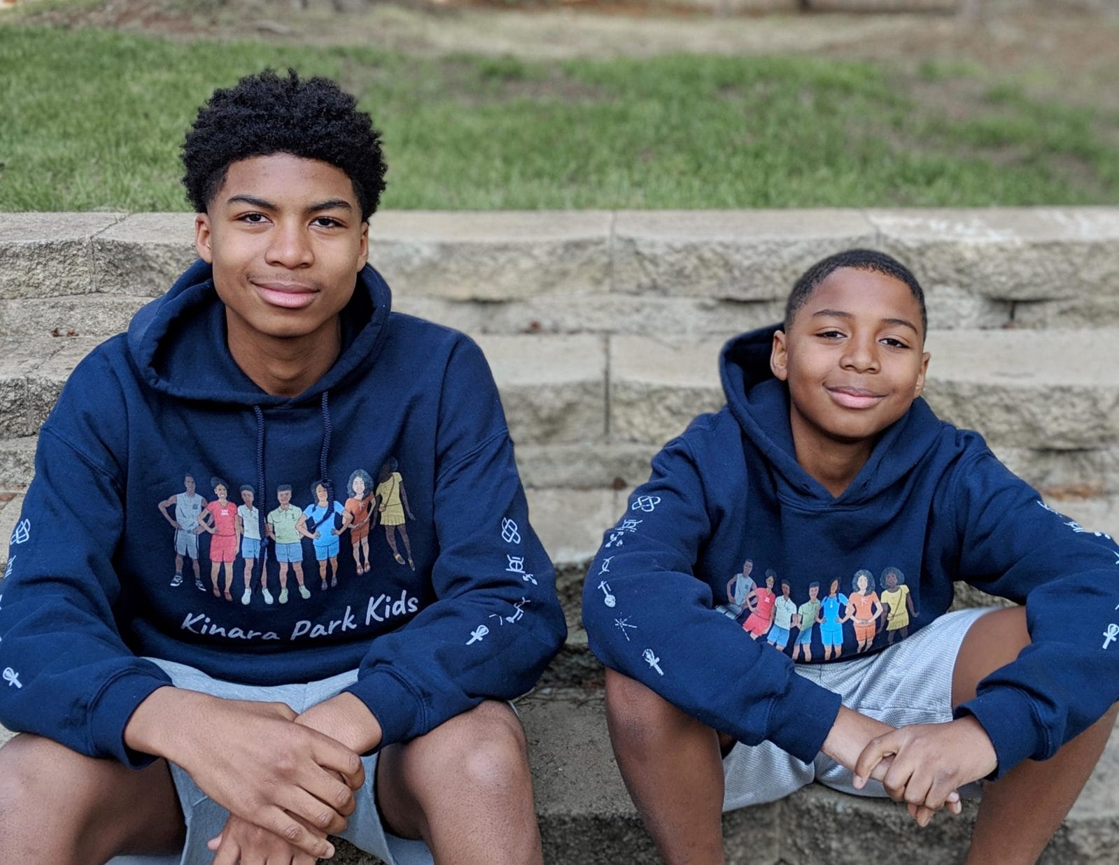 How I am teaching my children about the seven principles of Kwanzaa two children wearing kinara park sweaters- 7 principles of kwanzaa