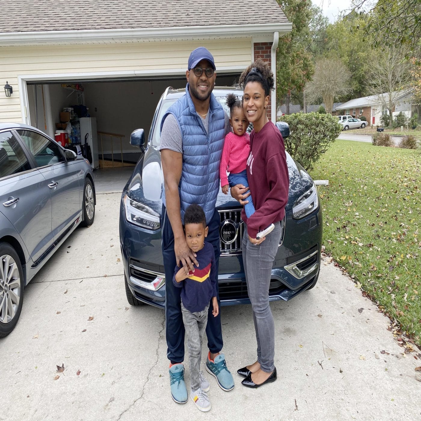 The 2021 Volvo XC90 is exactly what your family needs for long road trips family standing outside of their Volvo