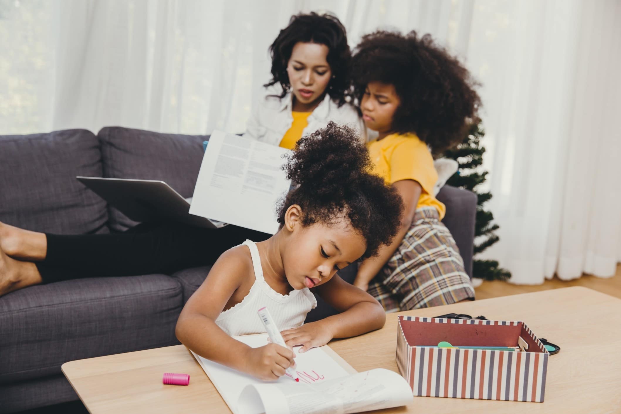 Moms are being forced to choose between their job and their kids in this pandemic mom helping two daughters with school