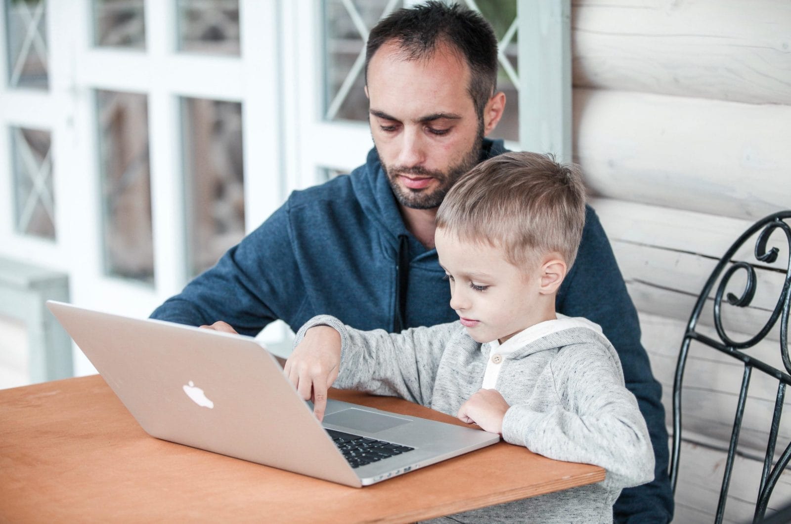 The pandemic forced 1 of us to stay home with our kid—we chose my husband dad working on a laptop with son in his lap