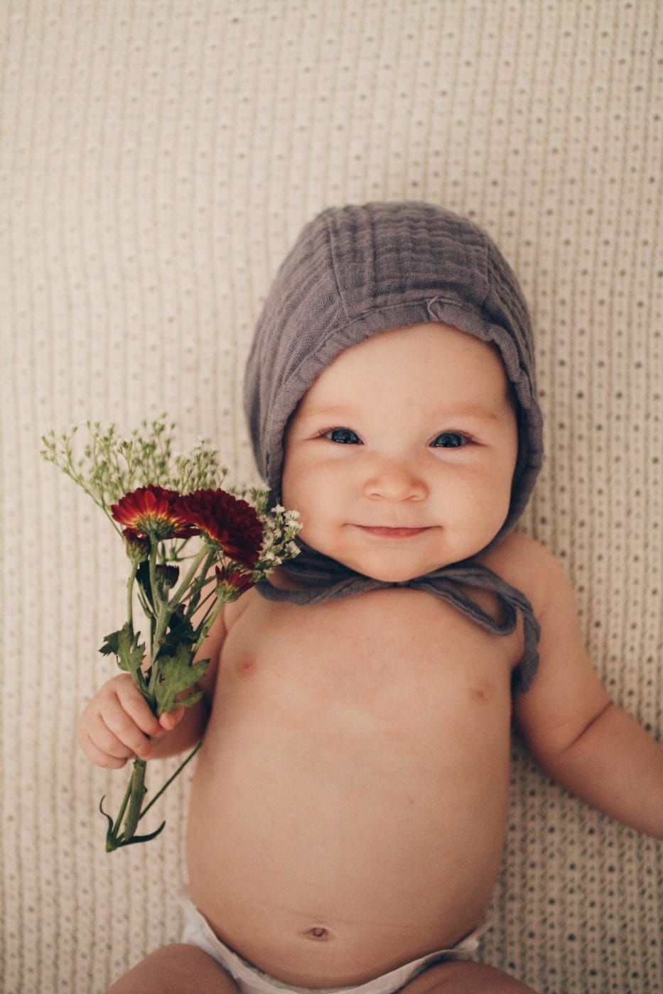 70 baby names inspired by nature for your future outdoor explorer baby holding bouquet of flowers - nature baby names