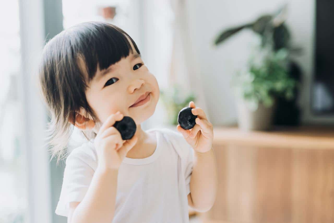 These are the nutrients your child needs for optimal brain development, according to a developmental neurobiologist little girl holding snacks