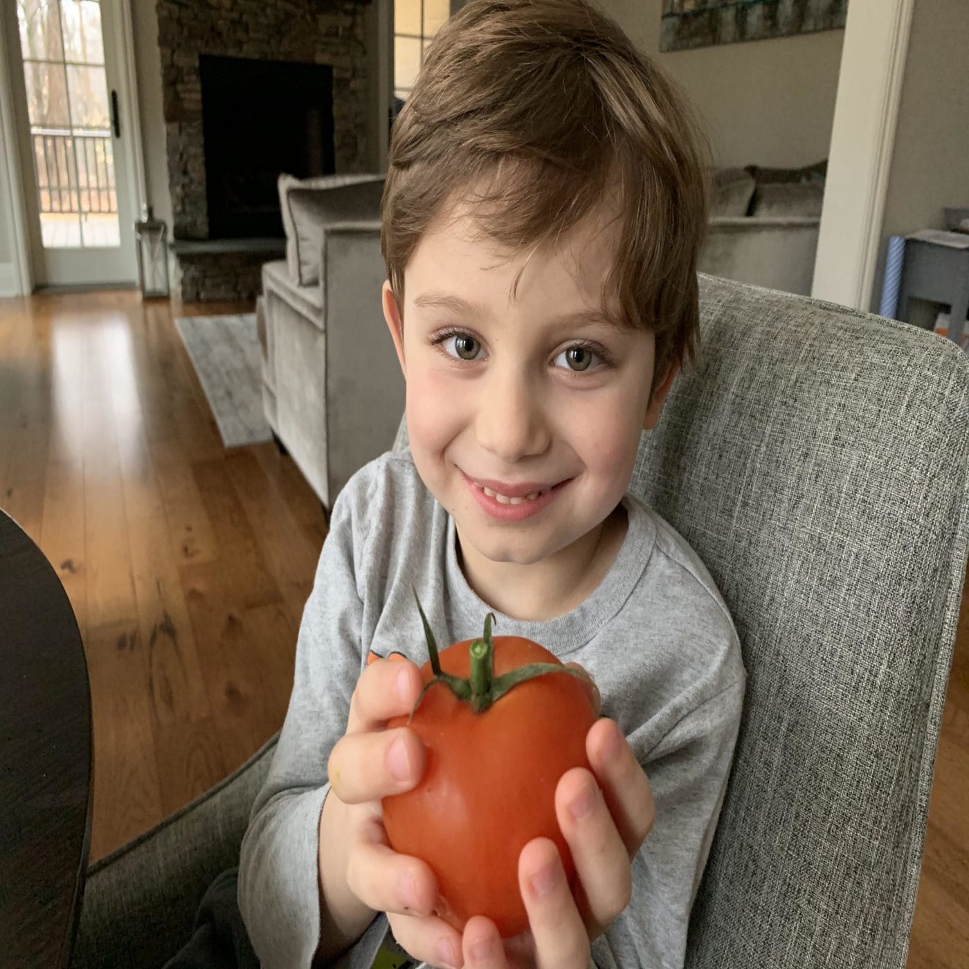 I made the viral baked feta pasta for my toddler and this is what happened little boy holding a tomato