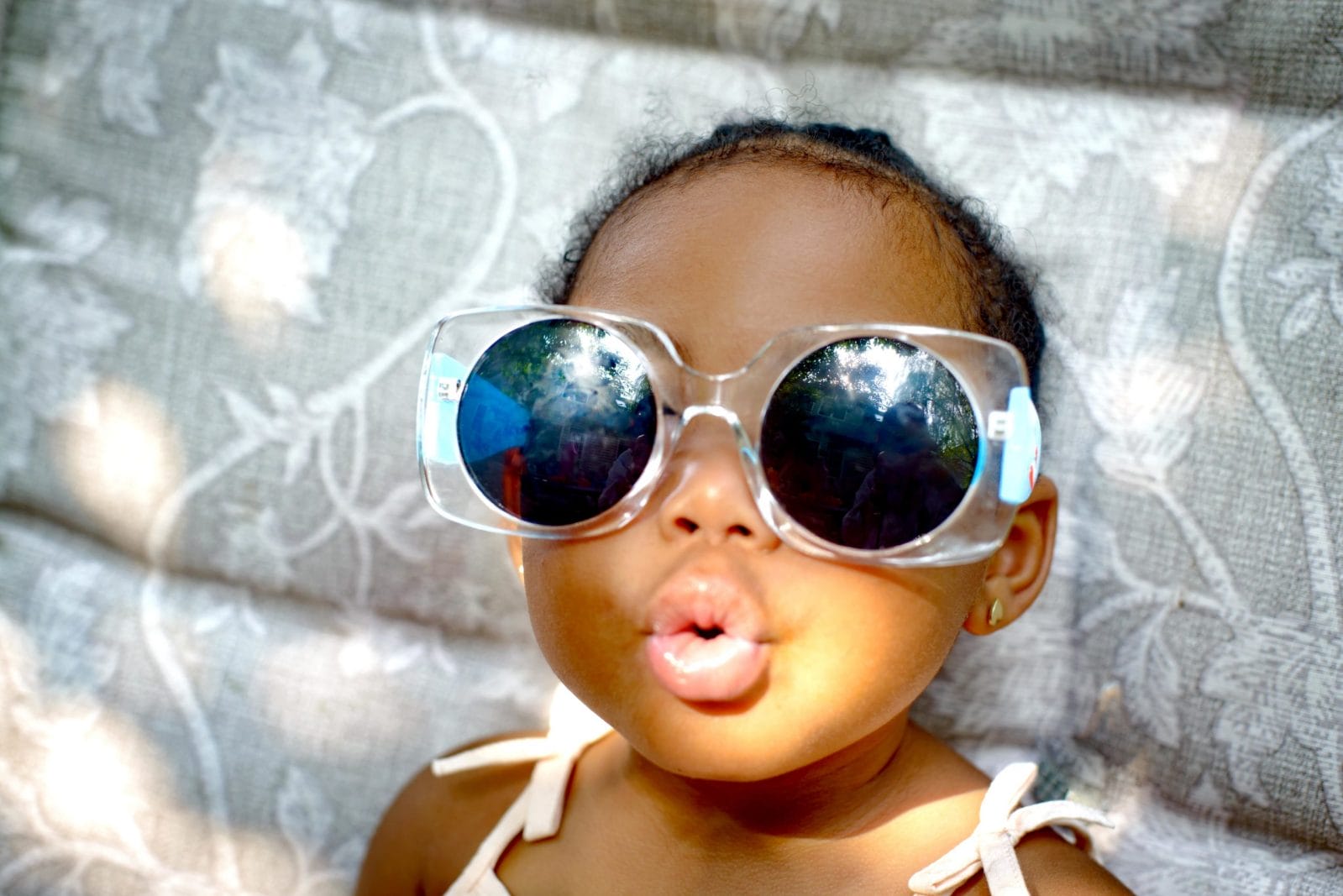 55 earthy, boho baby names for your free spirit baby girl wearing big sunglasses
