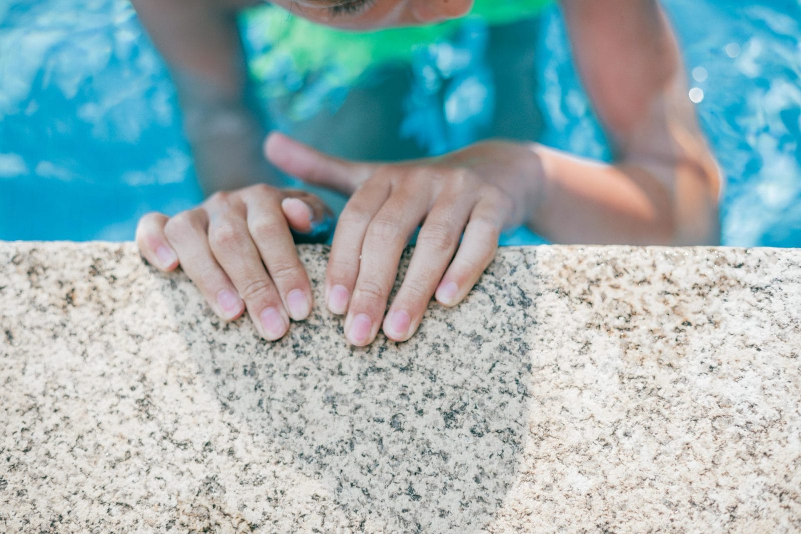 This dad urges you to rethink mermaid tails for your kids this summer little girls hands on the edge of a pool