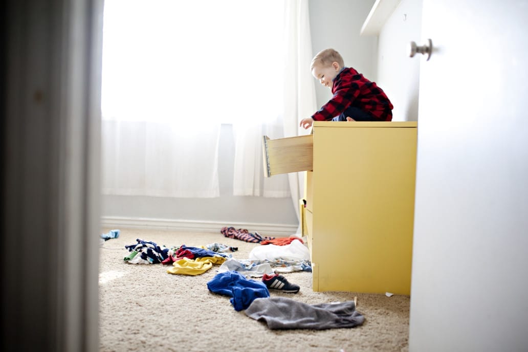 little boy playing on top of a dresser