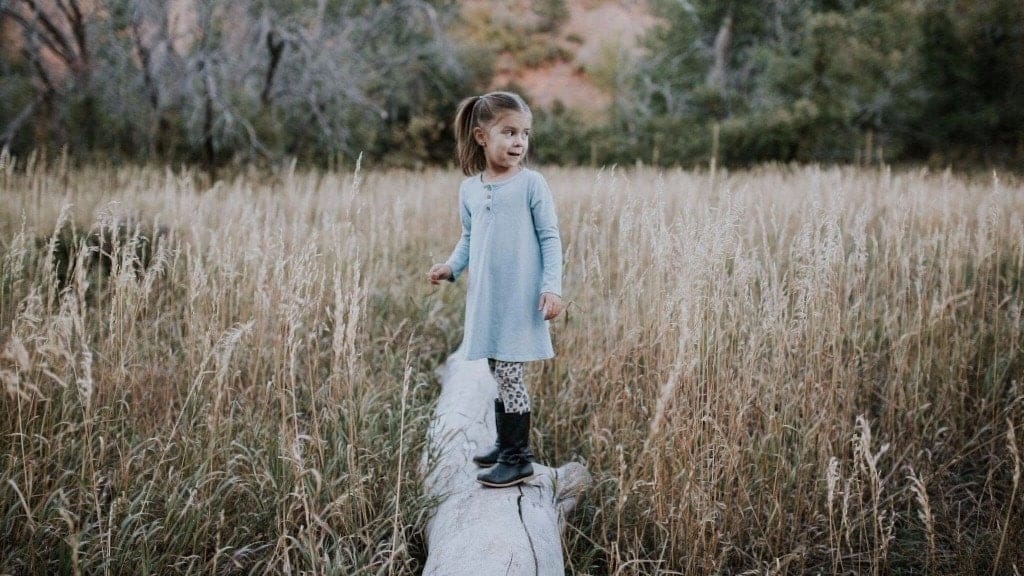 Raising overcomers: How to teach your kids to do hard things little girl standing on a log outside