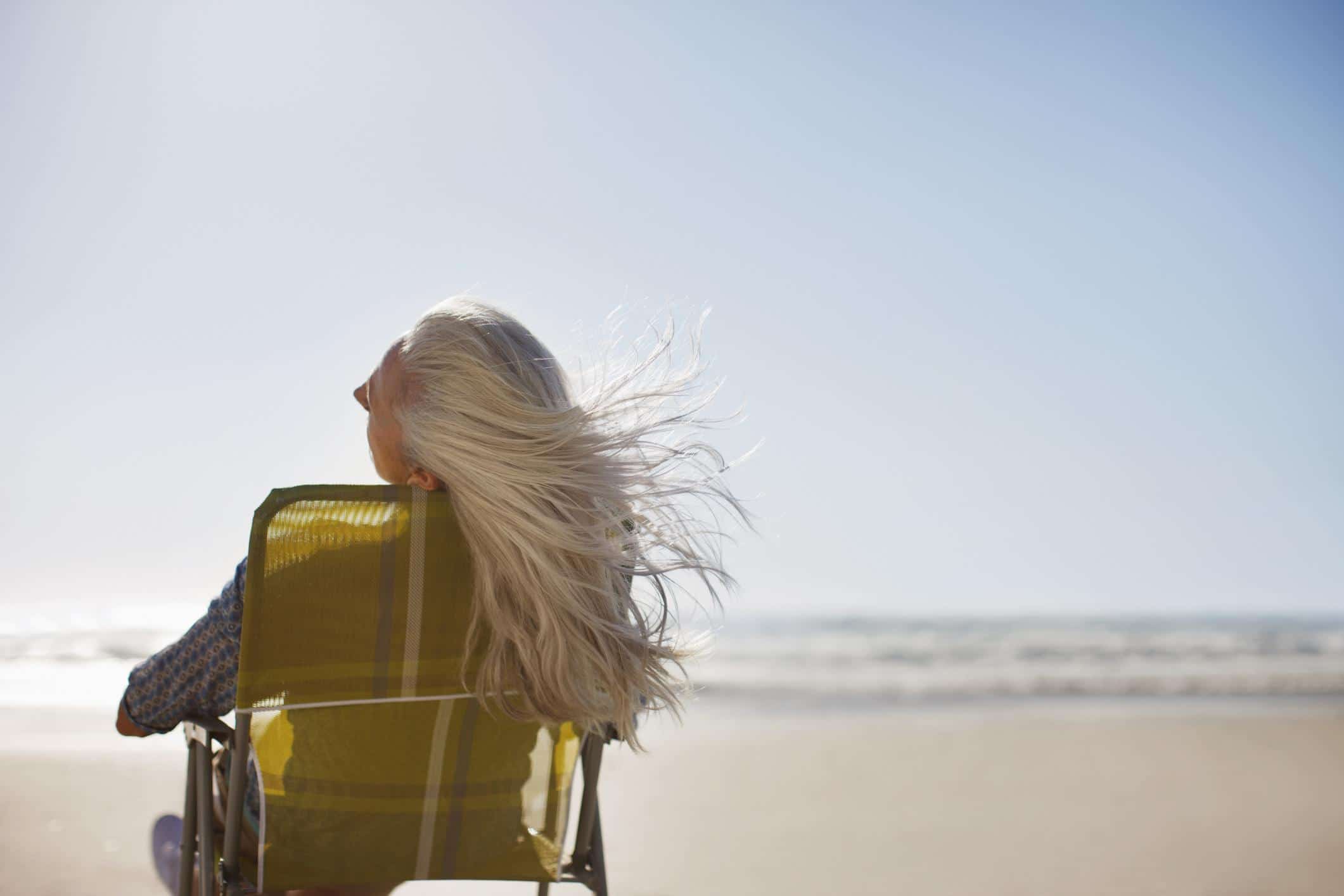 Science proves that gray hair is reversible—you read that right woman with hair flowing in the wind on a beach
