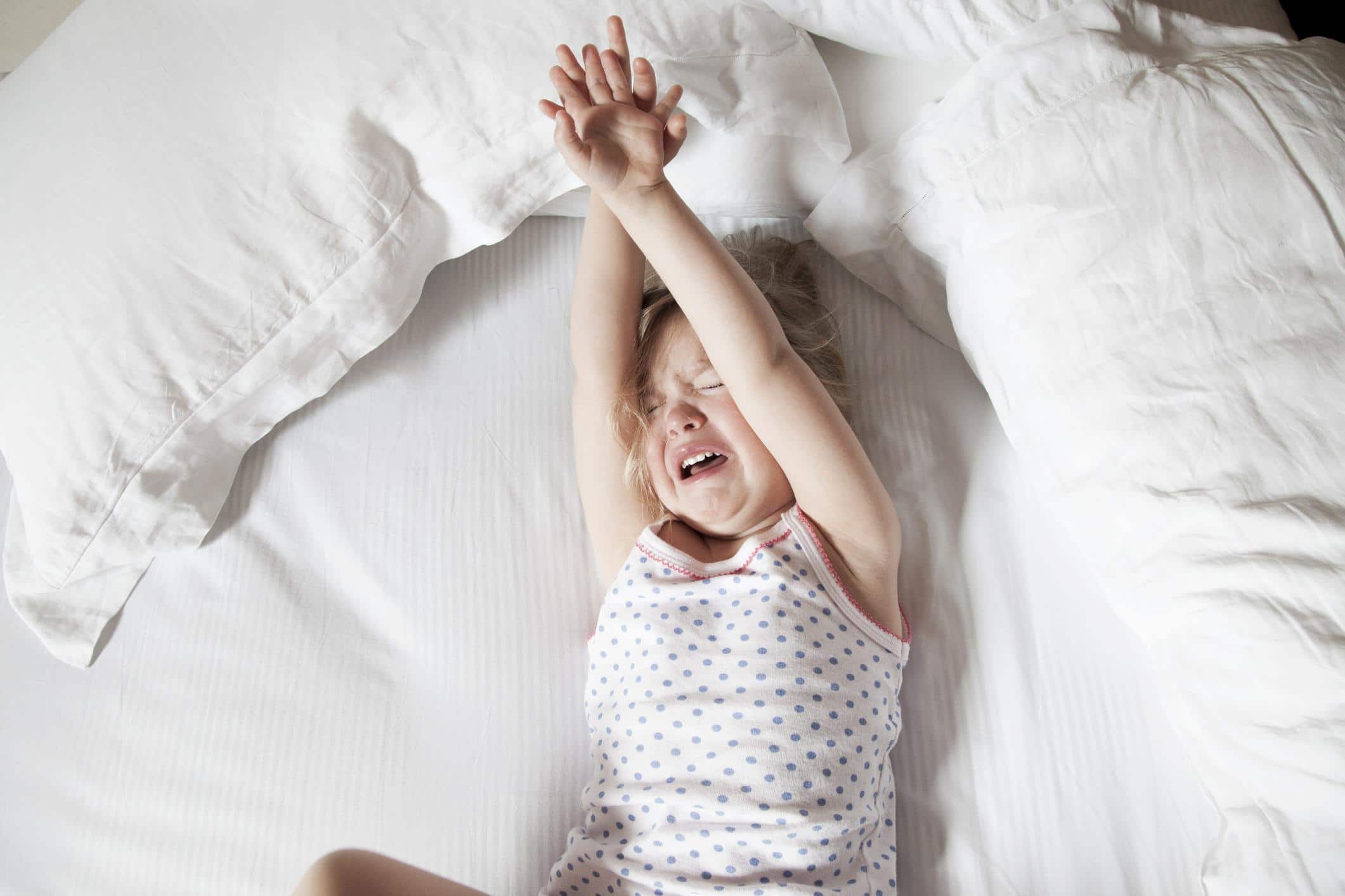 3 reasons not to ignore your child’s tantrums (and what to do instead) little girl playing on a bed