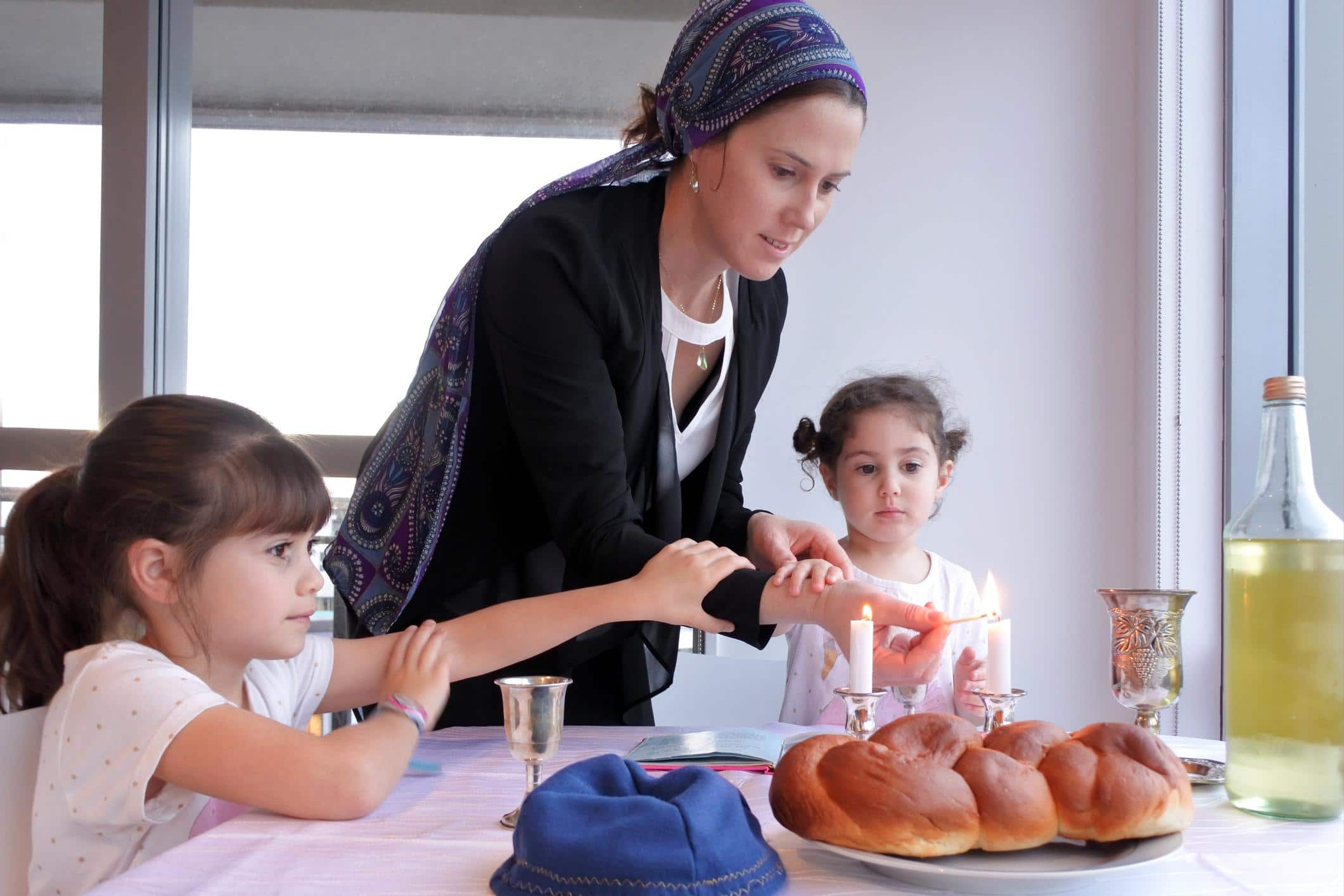 How I’m teaching my kids to love their Jewish heritage mom feeding her kids the sabbath meal - how to raise proud Jewish kids