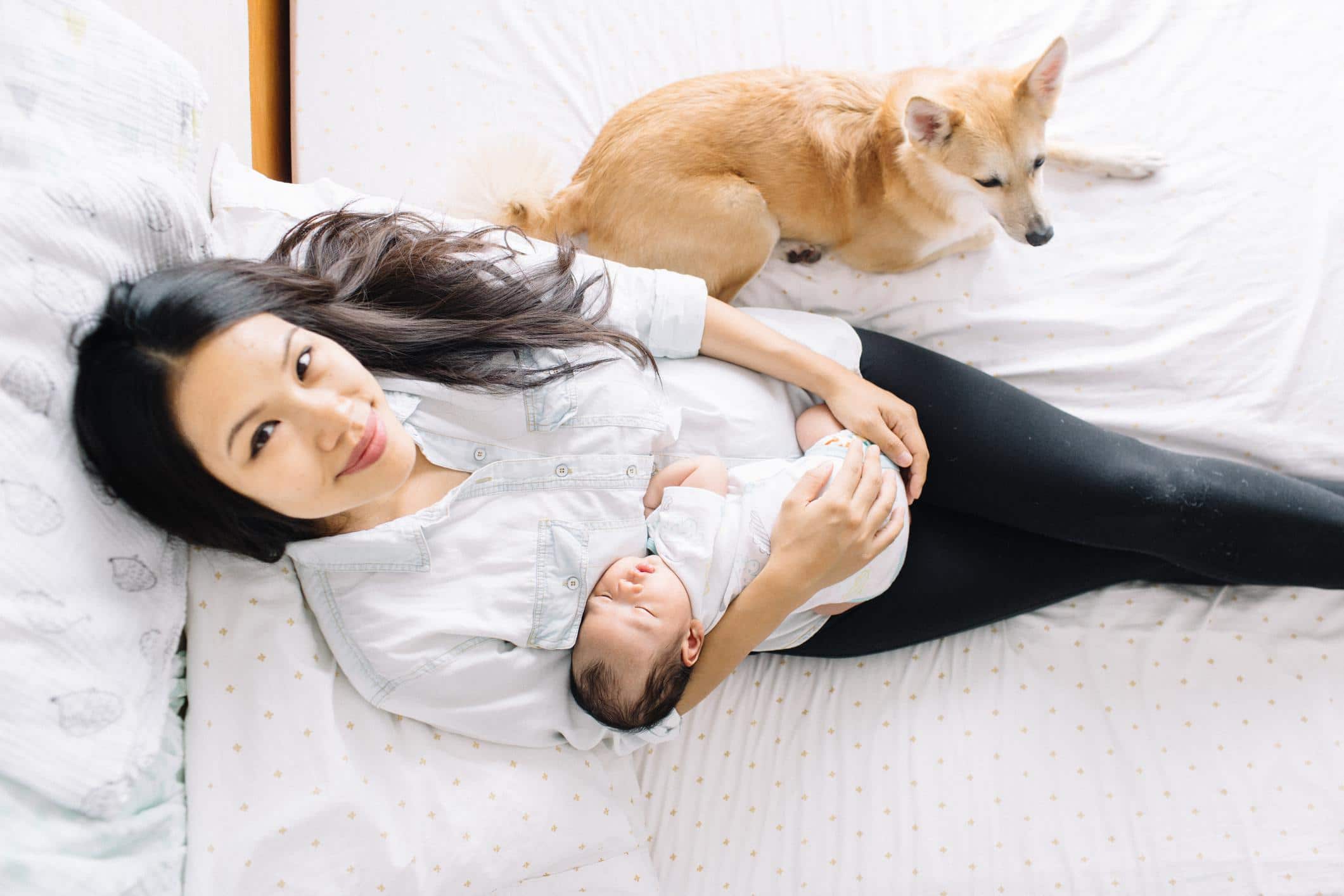 5 important reasons to practice postpartum rest, according to a midwife mom holding baby and looking at camera practicing postpartum rest