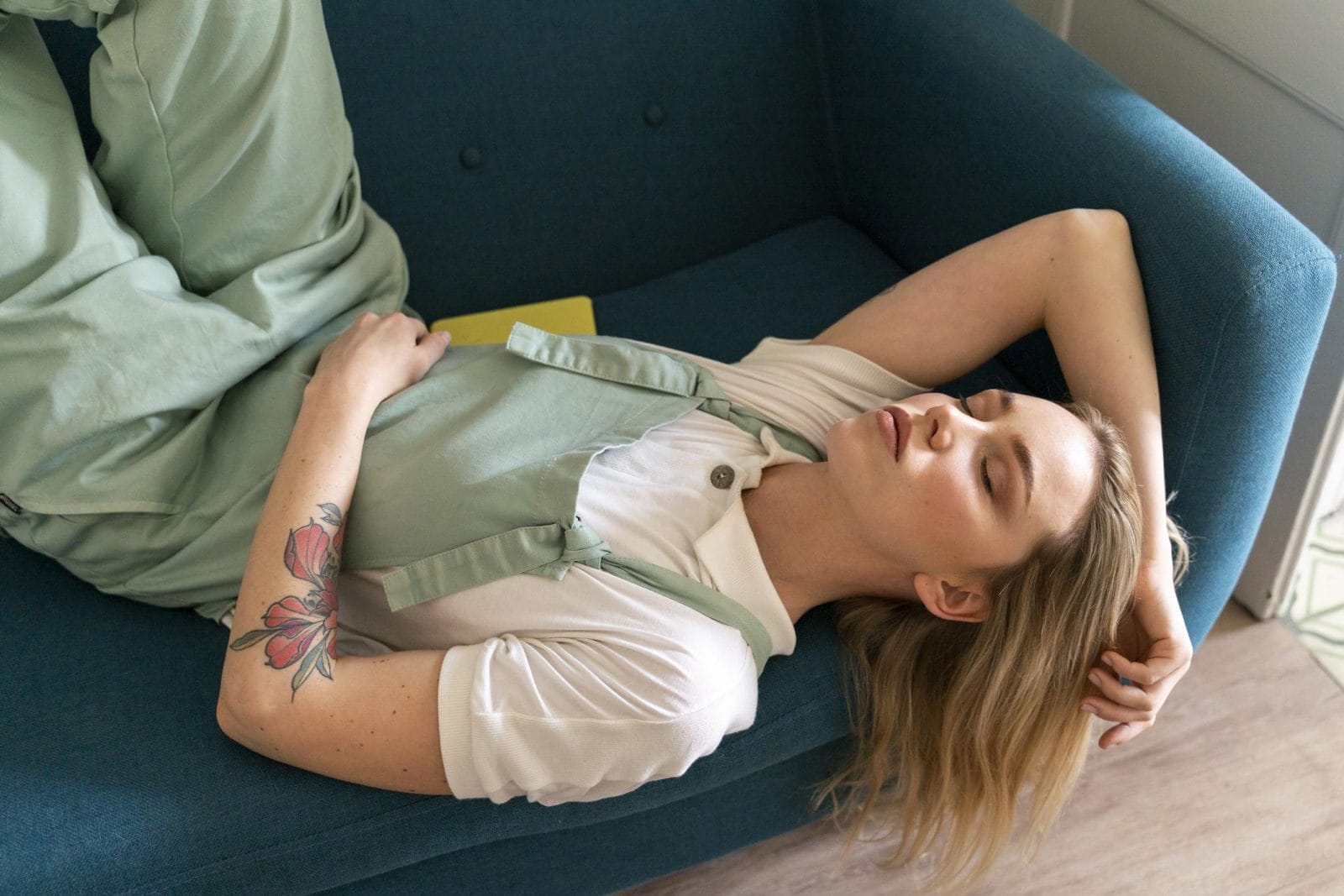 Dear mama, first-trimester fatigue is like nothing you’ve known before woman sleeping on a couch