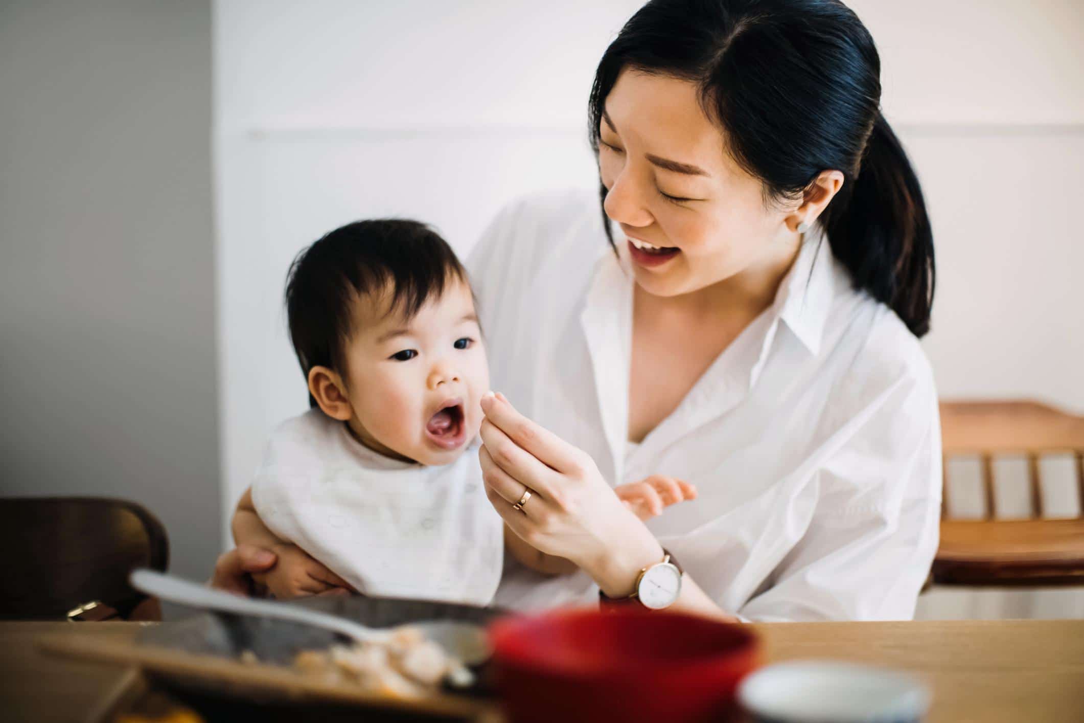 10 key foods to build your baby’s brain development foods to build baby's brain: mom feeding baby solid foods