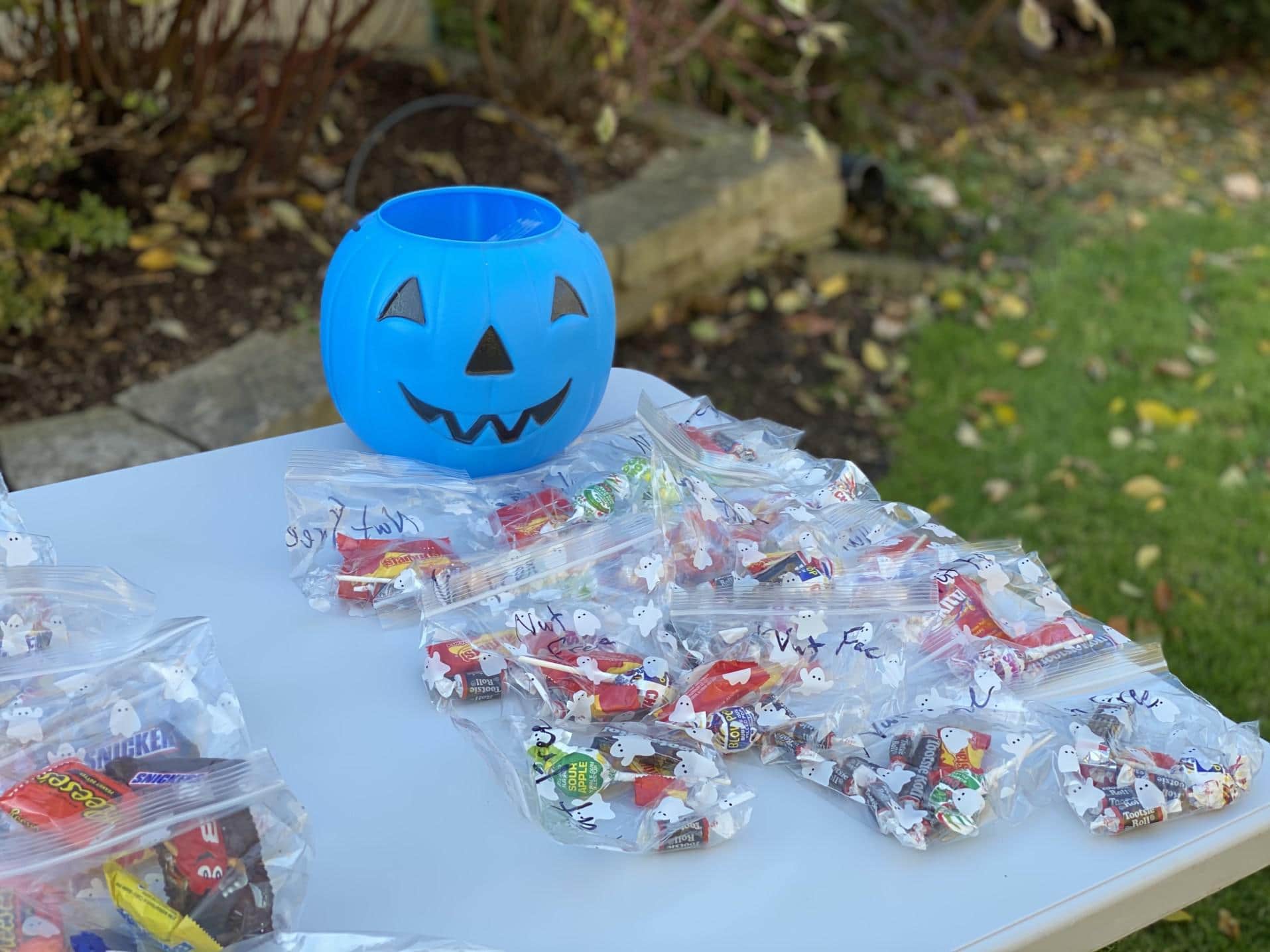 The teal pumpkin project: How you can support kids with allergies on Halloween blue pumpkin on table with candy- teal pumpkin project