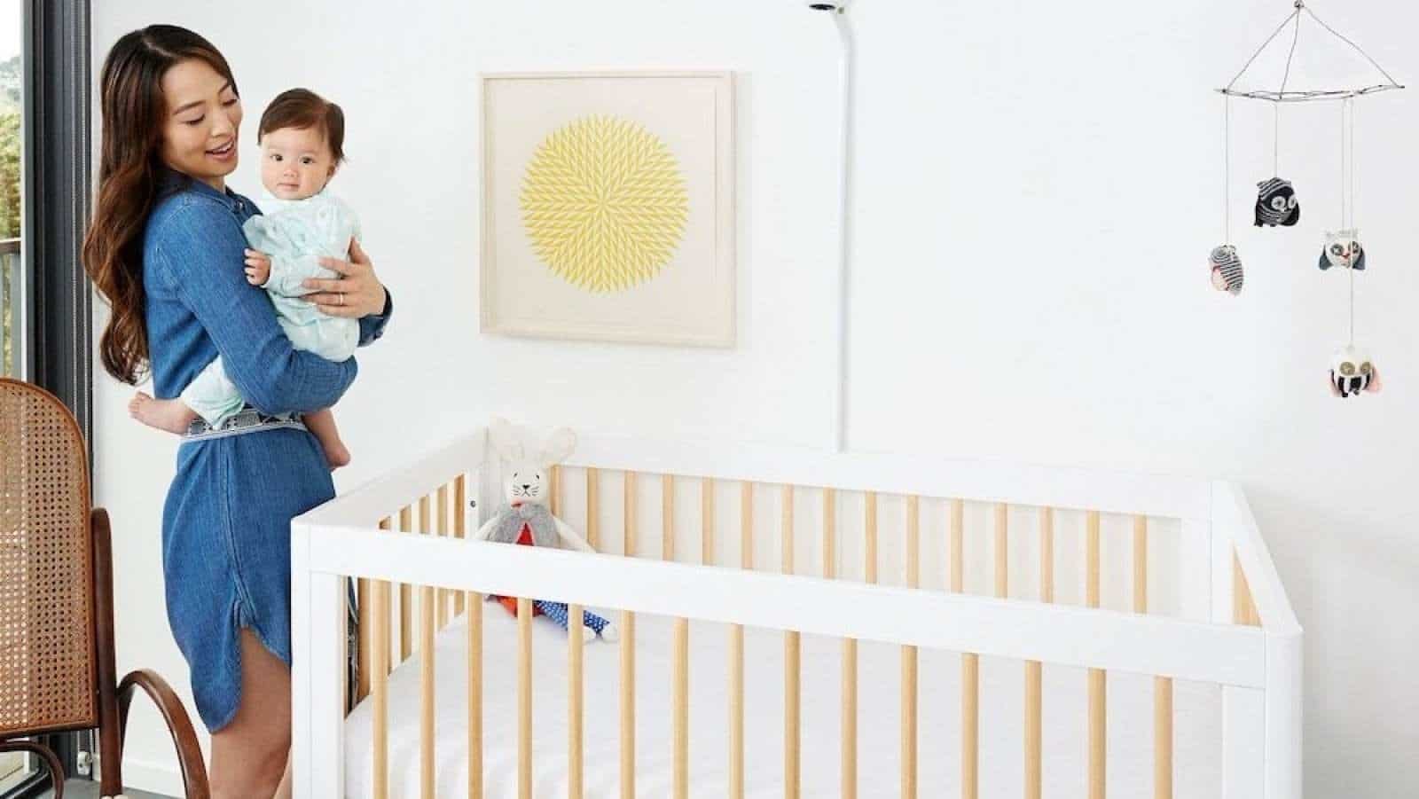 9 innovative baby products you’re going to want, mama mom putting baby in a crib