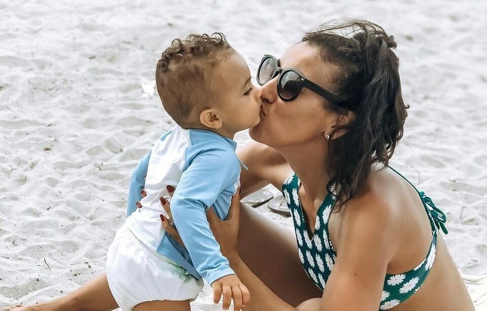 I travel with my young kids to build their hearts, not memories mom kissing baby on a beach