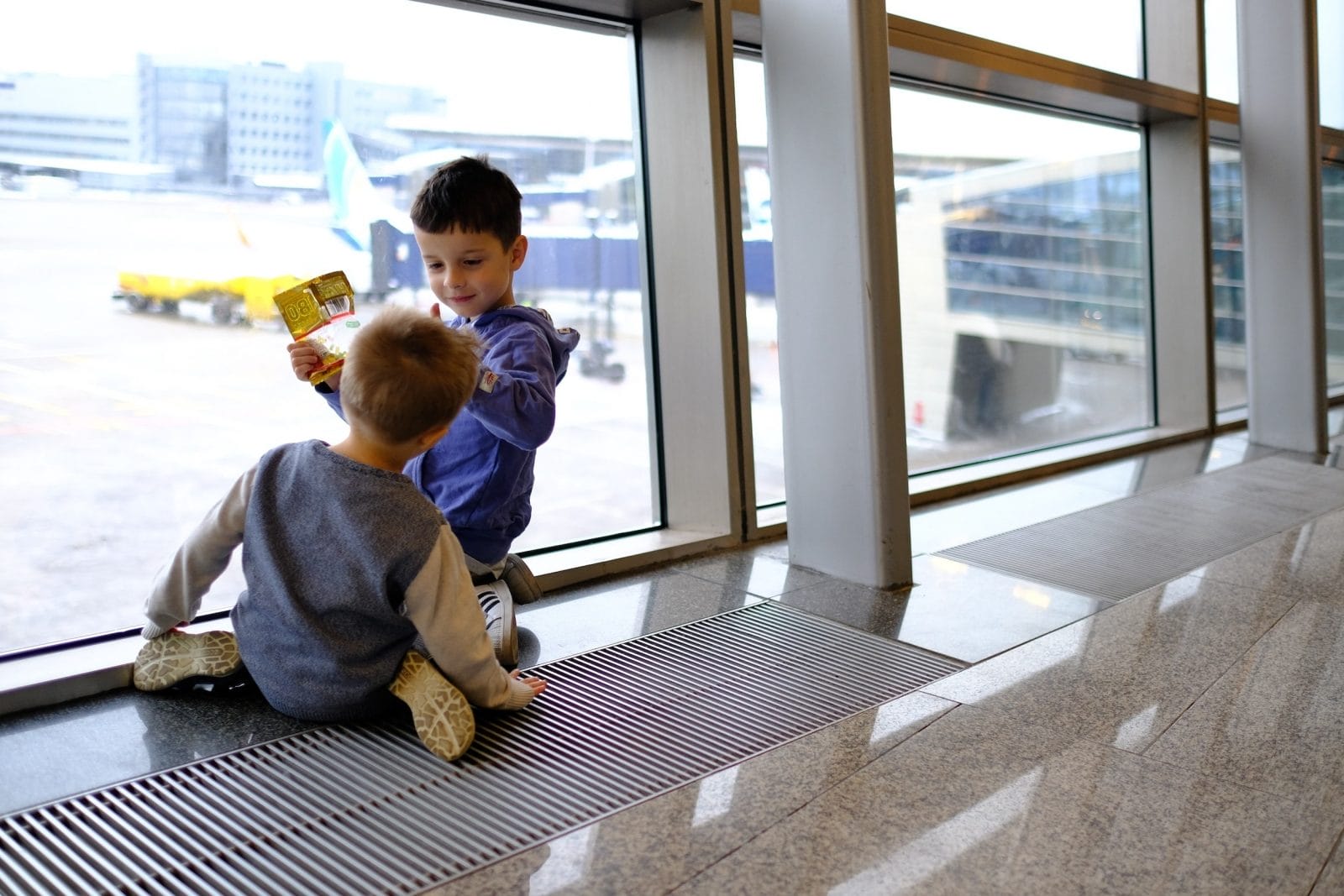 10 overlooked reasons why traveling with your kids is worth it two kids playing at an airport