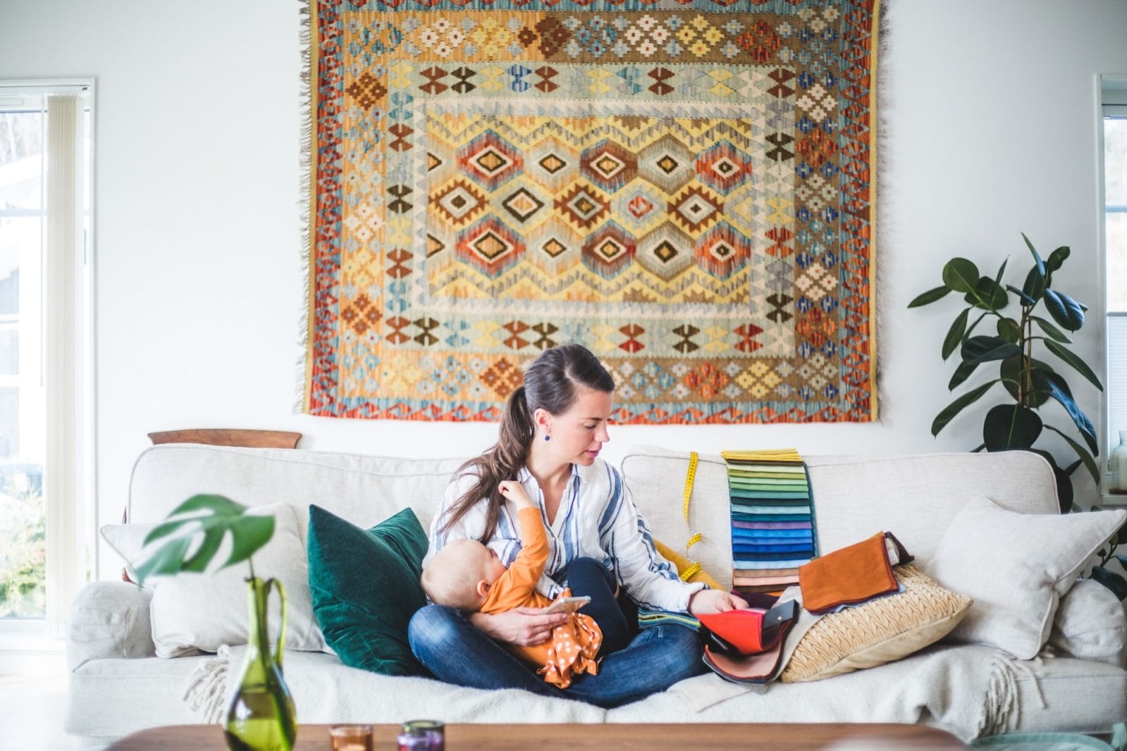 8 productivity strategies for moms who are stressed about doing it all mom on a computer while holding a baby