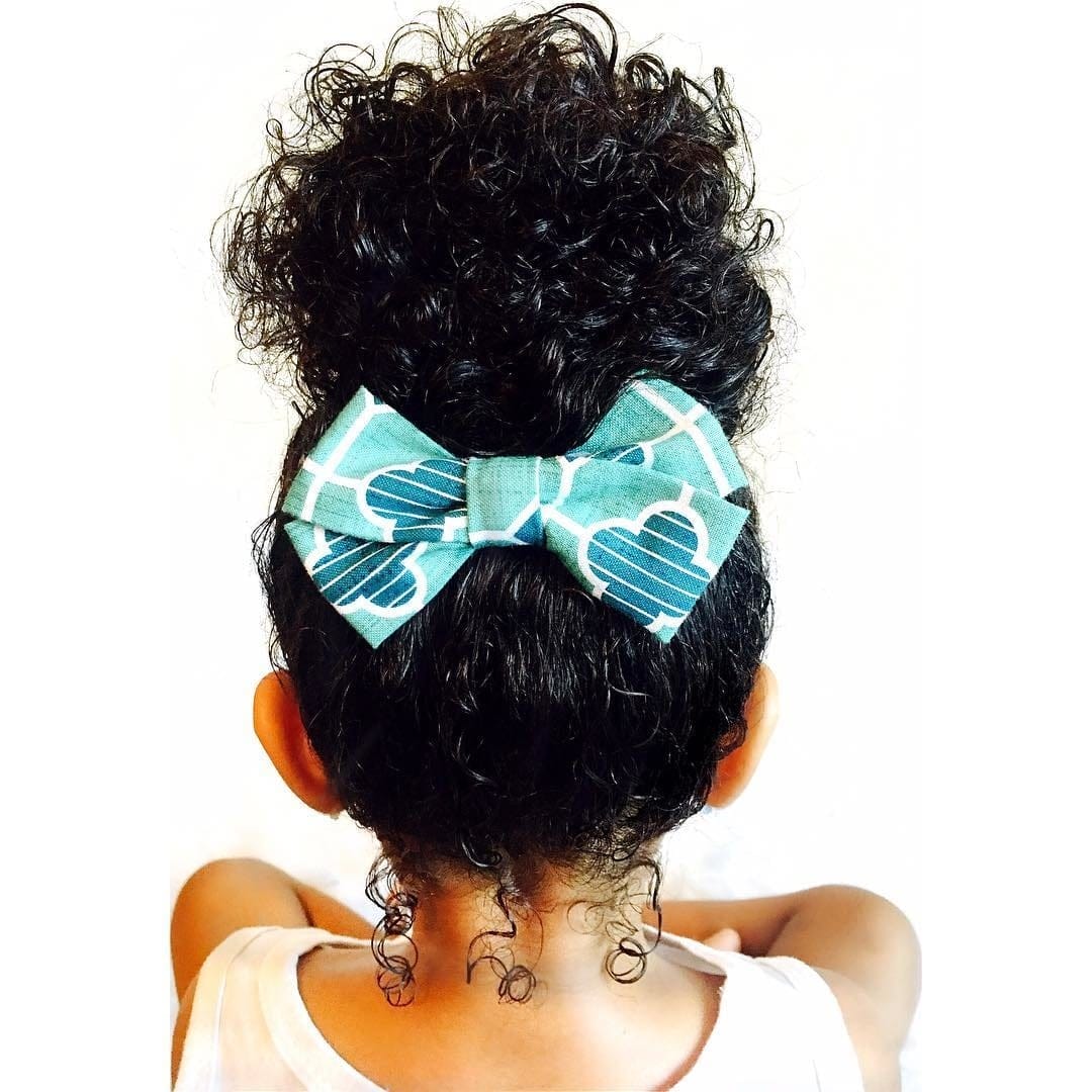 41 inspo-worthy hairstyles for kids of all ages illustration of a little girl wearing a bow under a bun