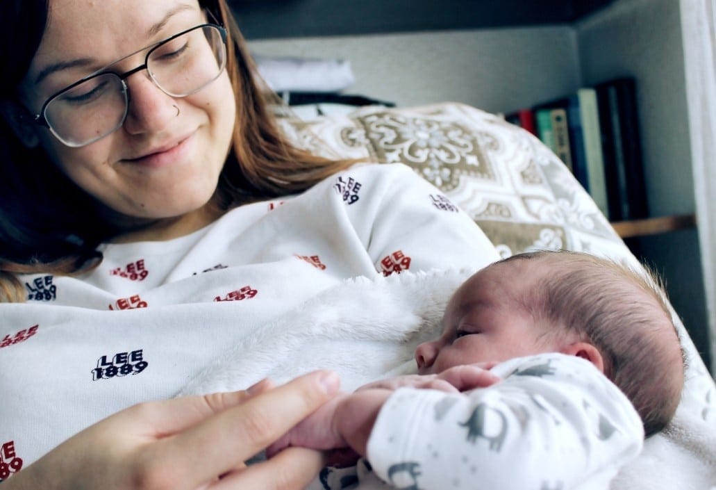 5 expert tips for healing your pelvic floor from birth (without leaving home) mom holding newborn baby laying down