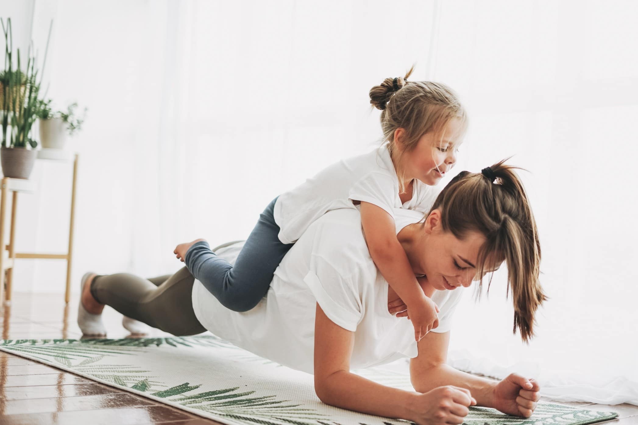 50+ fun workout songs to motivate you, mama mom doing a plank with daughter on her back