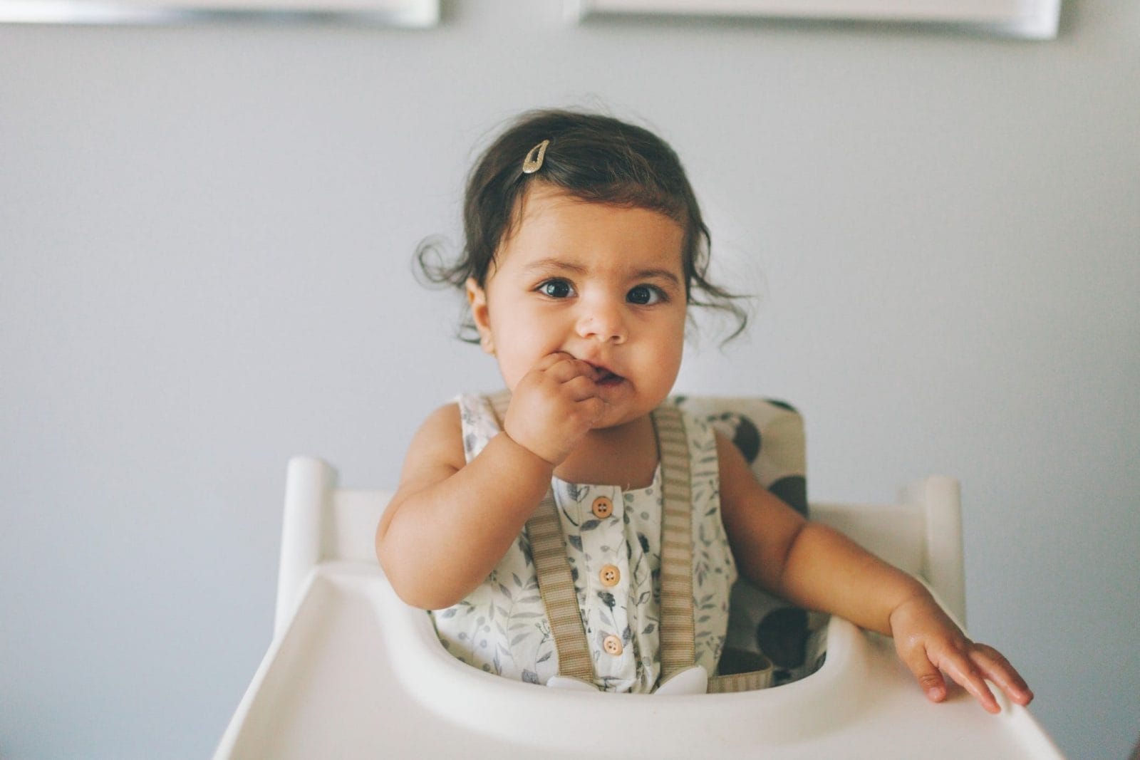 The best brain-boosting food for kids—and how to get them to eat it little girl eating food in a high chair