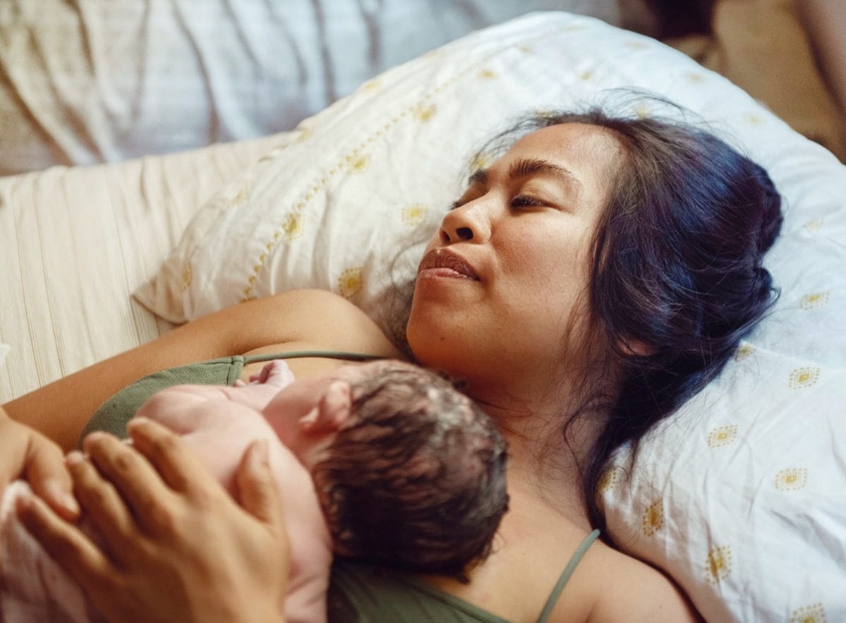 As a new mom I have so much love for my baby—but I’m struggling to love myself mom holding newborn baby against her chest