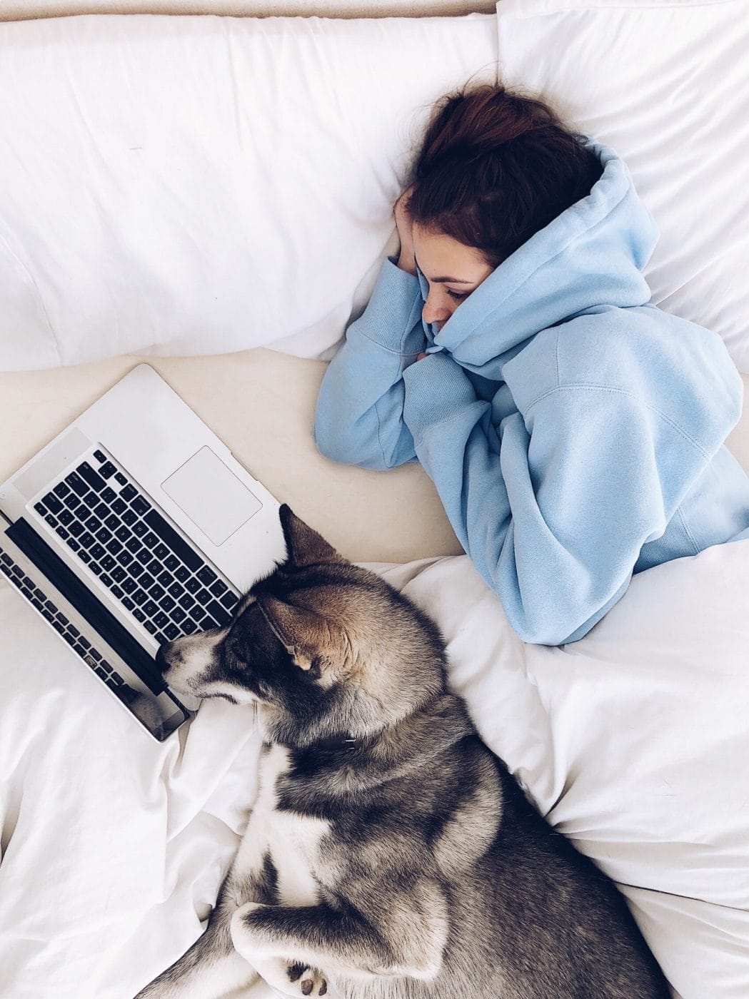 Need a break from the news? Here are 50+ feel-good movies + shows to stream tonight, mama woman watching a movie on a laptop in bed
