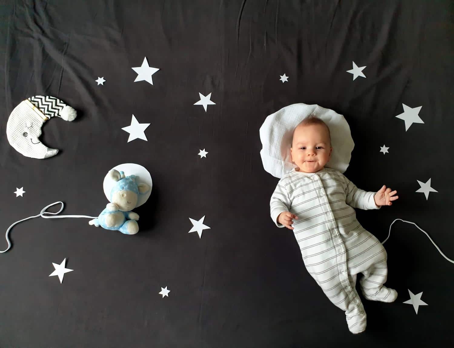 100 magical, moon-inspired baby names baby laying on a galaxy blanket- baby names that mean moon