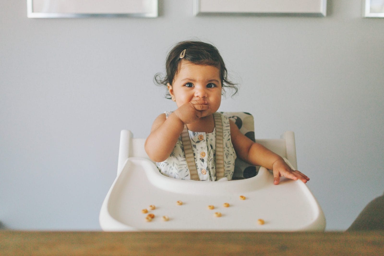 How much solid food should babies eat in their first year? A surprising new study sheds light on guidelines baby eating solid food in a high chair