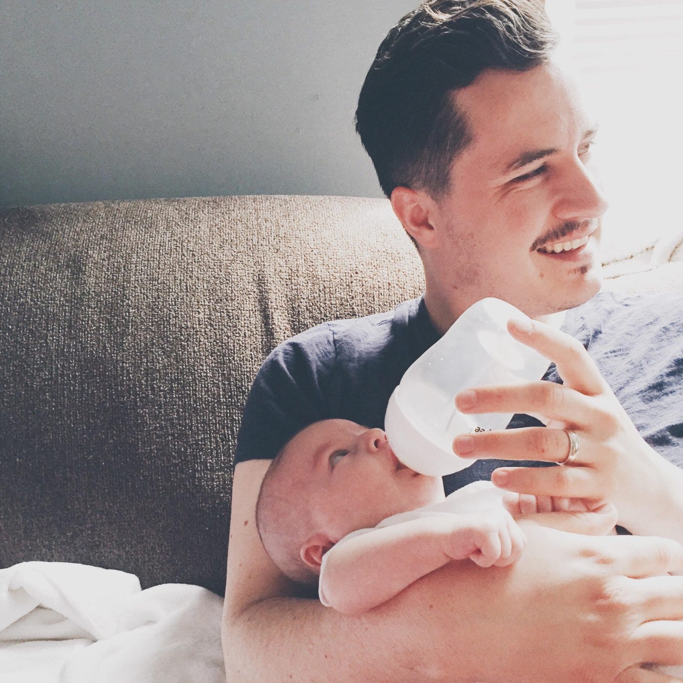 4-week-old baby feeding schedule & amounts dad giving a baby a bottle - 4-week-old baby feeding schedule