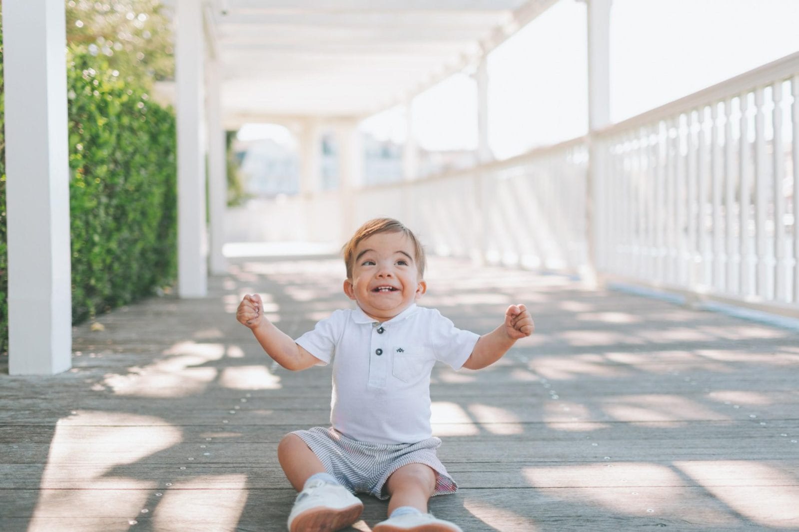 11-month-old baby milestones happy child sitting on the sidewalk - 11-month milestones