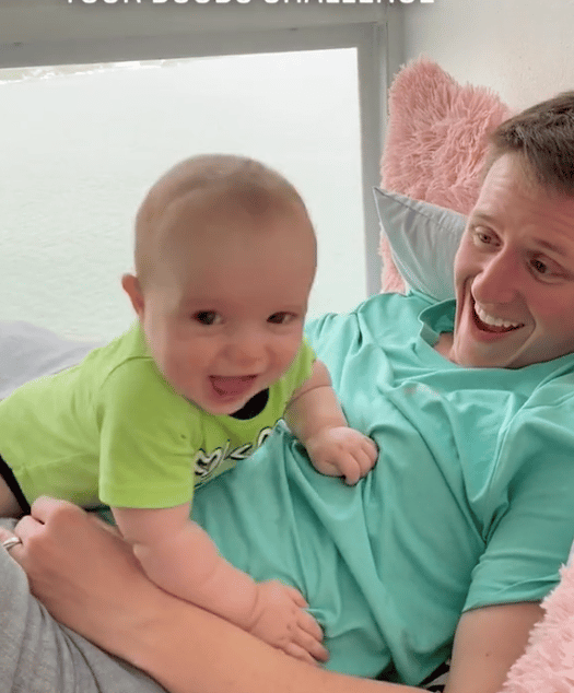Moms are ‘flashing’ their breastfed babies in a viral Tiktok trend dad laughing with newborn baby climbing on him