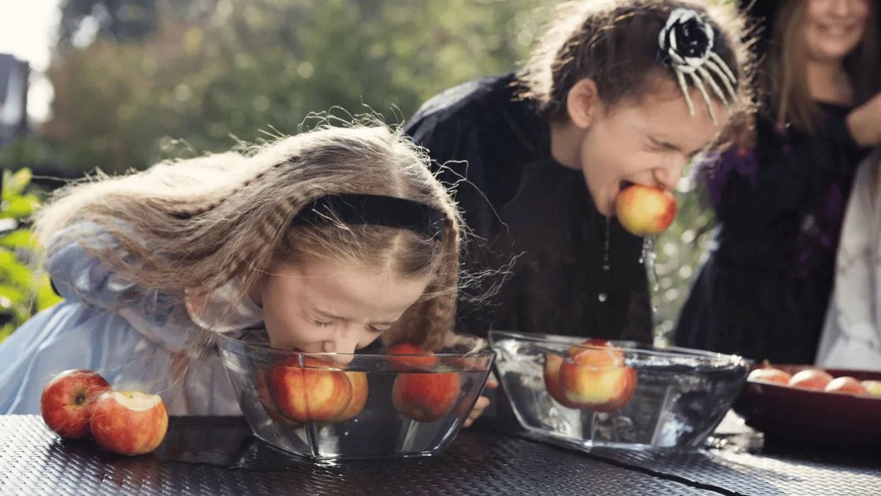 19 kids Halloween game ideas for any spooktacular soirée two girls bobbing for apples - kids Halloween games ideas