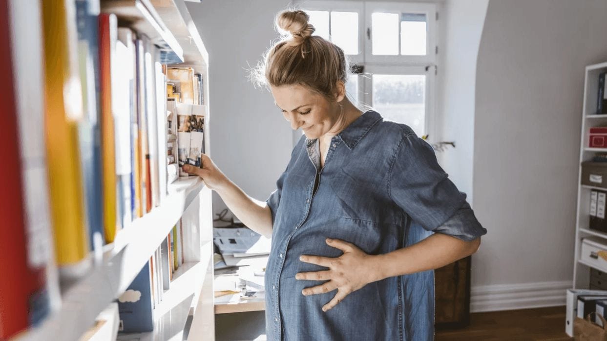 Am I in labor? 5 early signs of labor to know about pregnant mom holding her belly wondering about early signs of labor