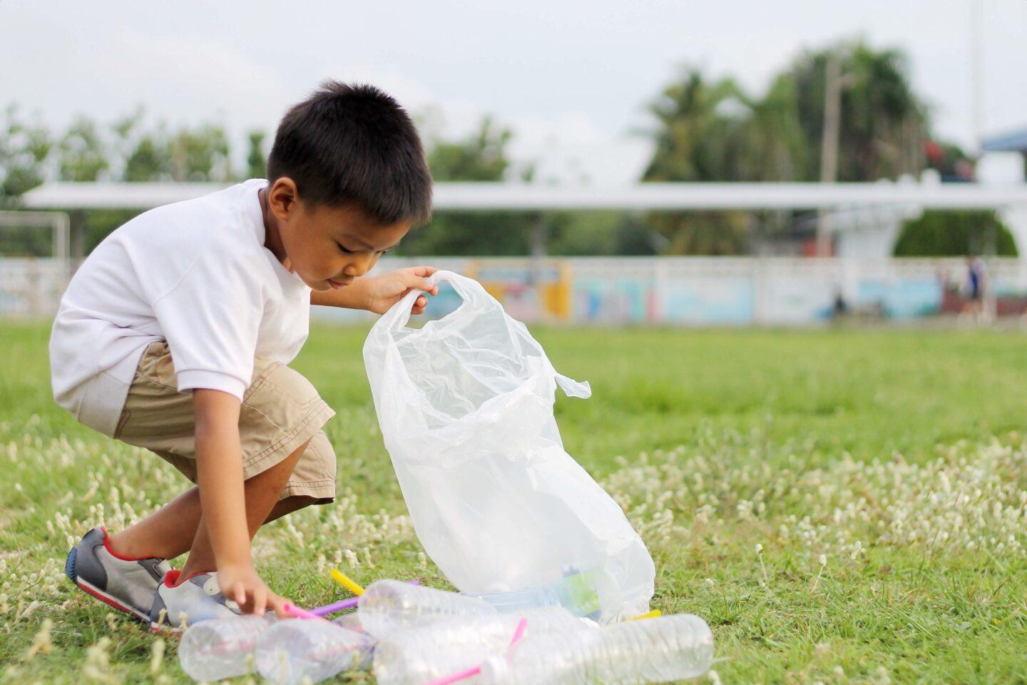 How to get your family—even little kids!— to start volunteering child picking up empty water bottles from grass-volunteering with kids