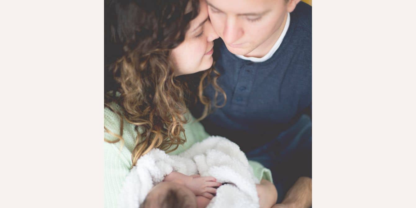 Rachel on the anger and grief she felt from losing her baby mom and dad snuggling a newborn baby - essay on pregnancy loss