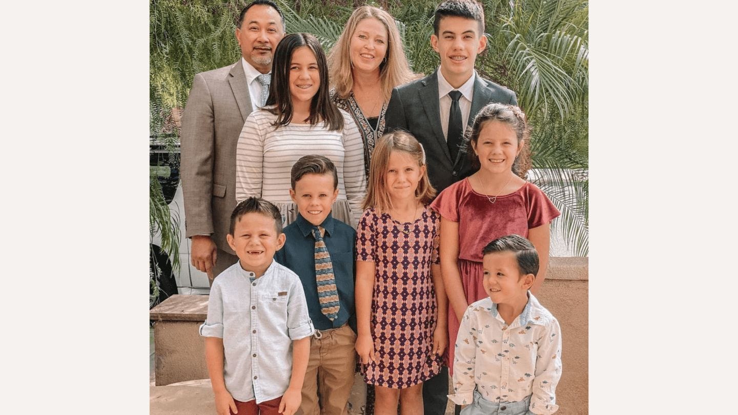 Instead of being ’empty nesters,’ this couple adopted 7 orphaned siblings parents pose with their 7 adopted siblings