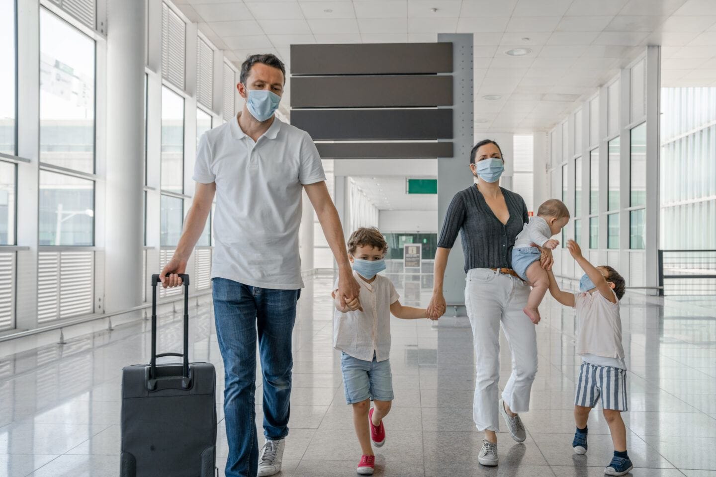 17 pandemic-era essentials for traveling with babies & kids Family travelling with face masks for COVID-19