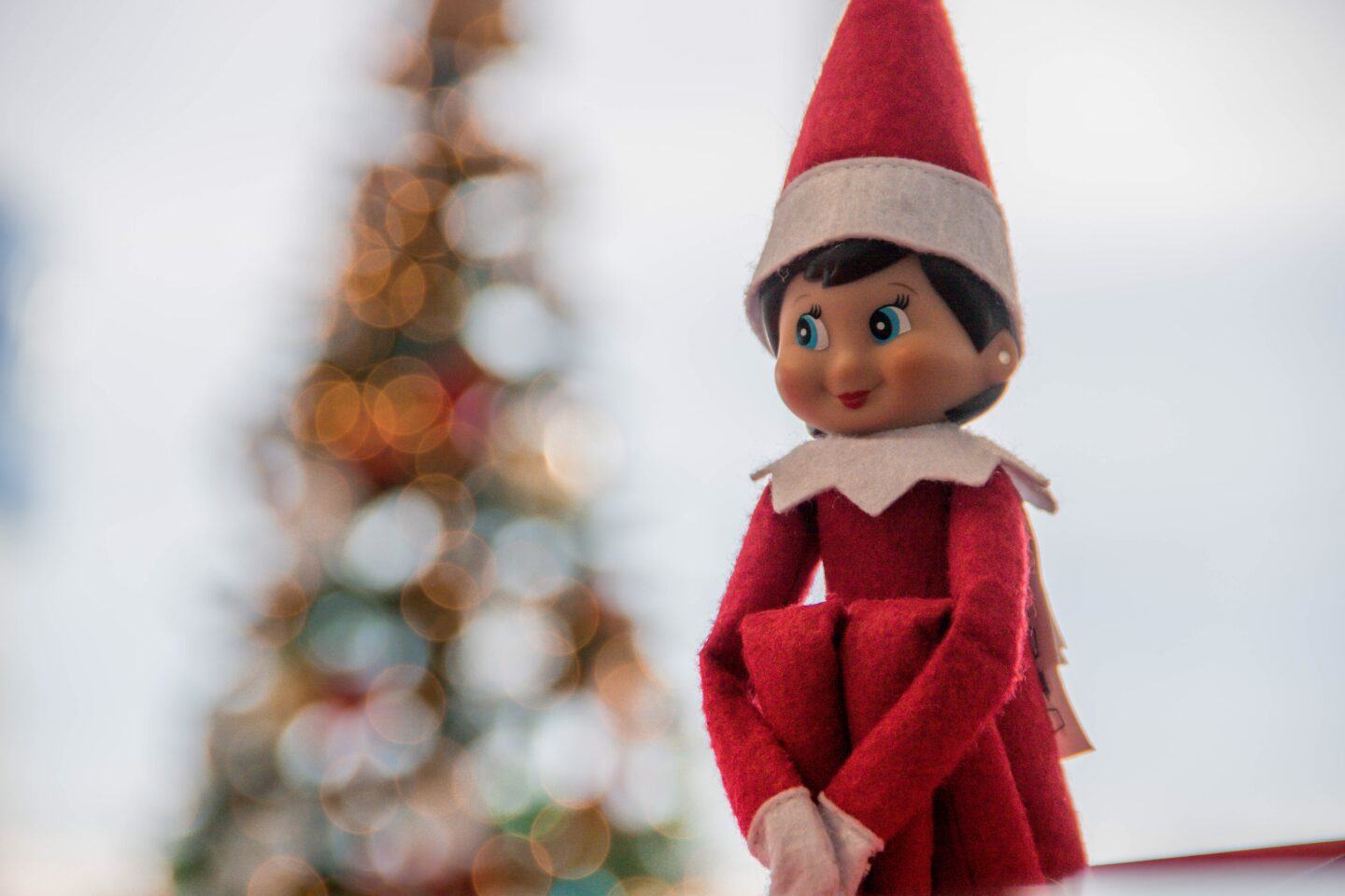 You don’t have to hate the Elf on the Shelf, I promise elf on the shelf posing near christmas tree