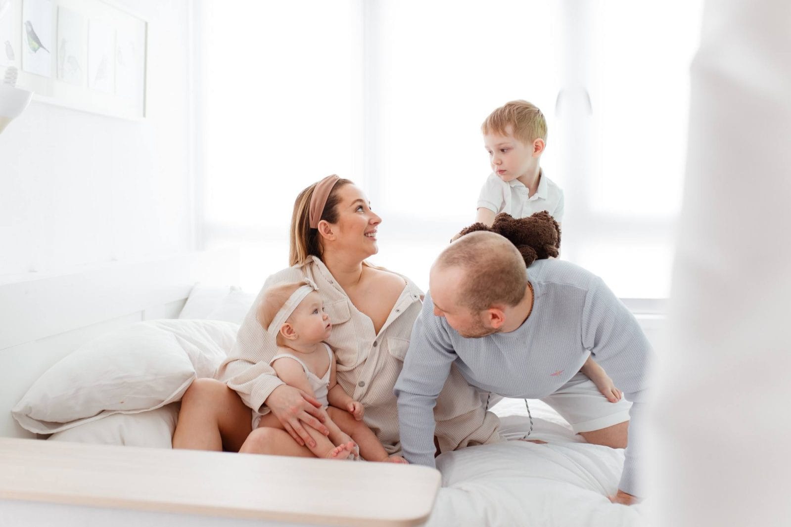 ‘Divide and conquer’ works for us—and this unisex diaper bag makes it easy Family resting on a bed and having fun