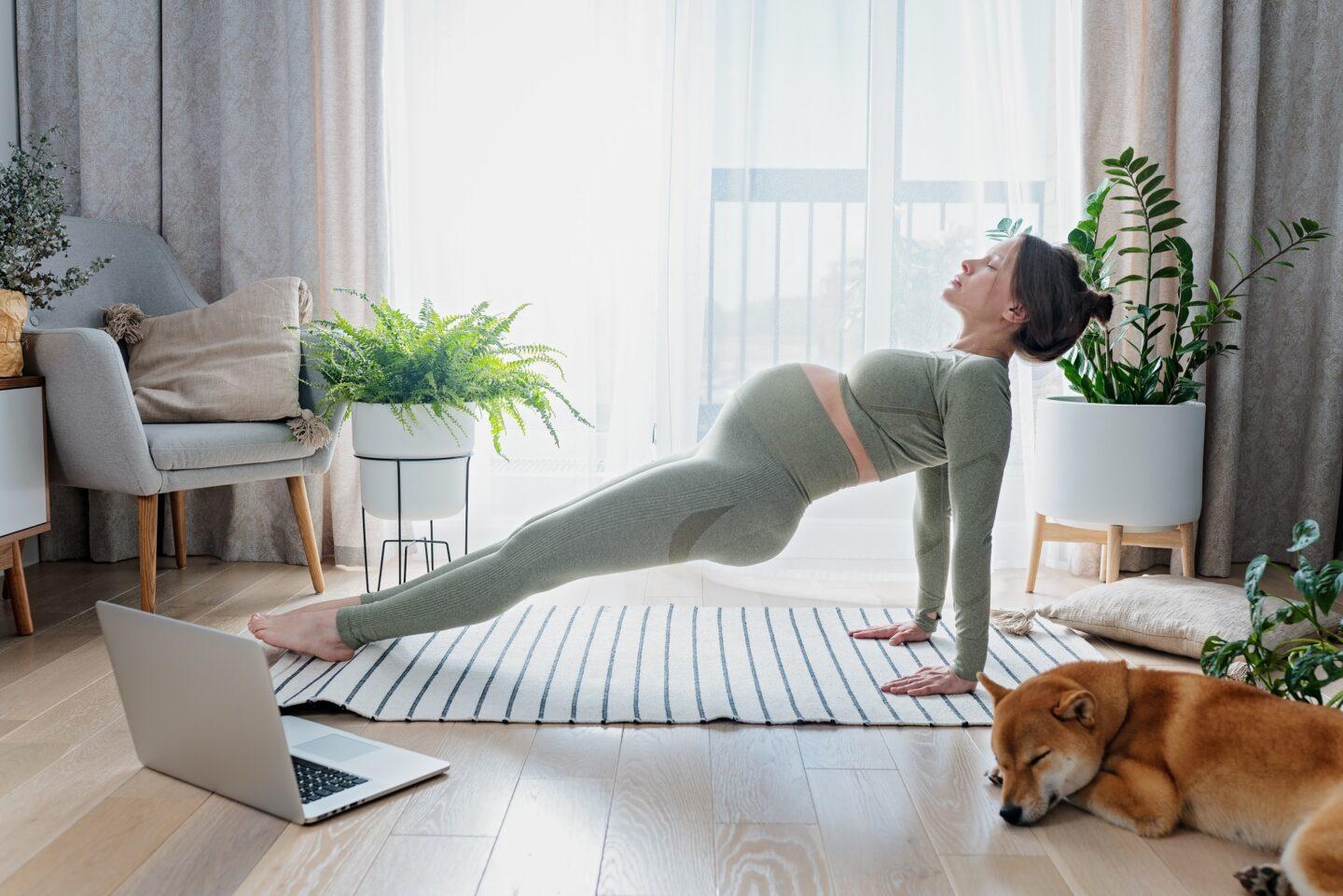 The Bloom Method takes the mystery out of prenatal and postnatal exercise Pregnant woman exercising in living room with laptop open