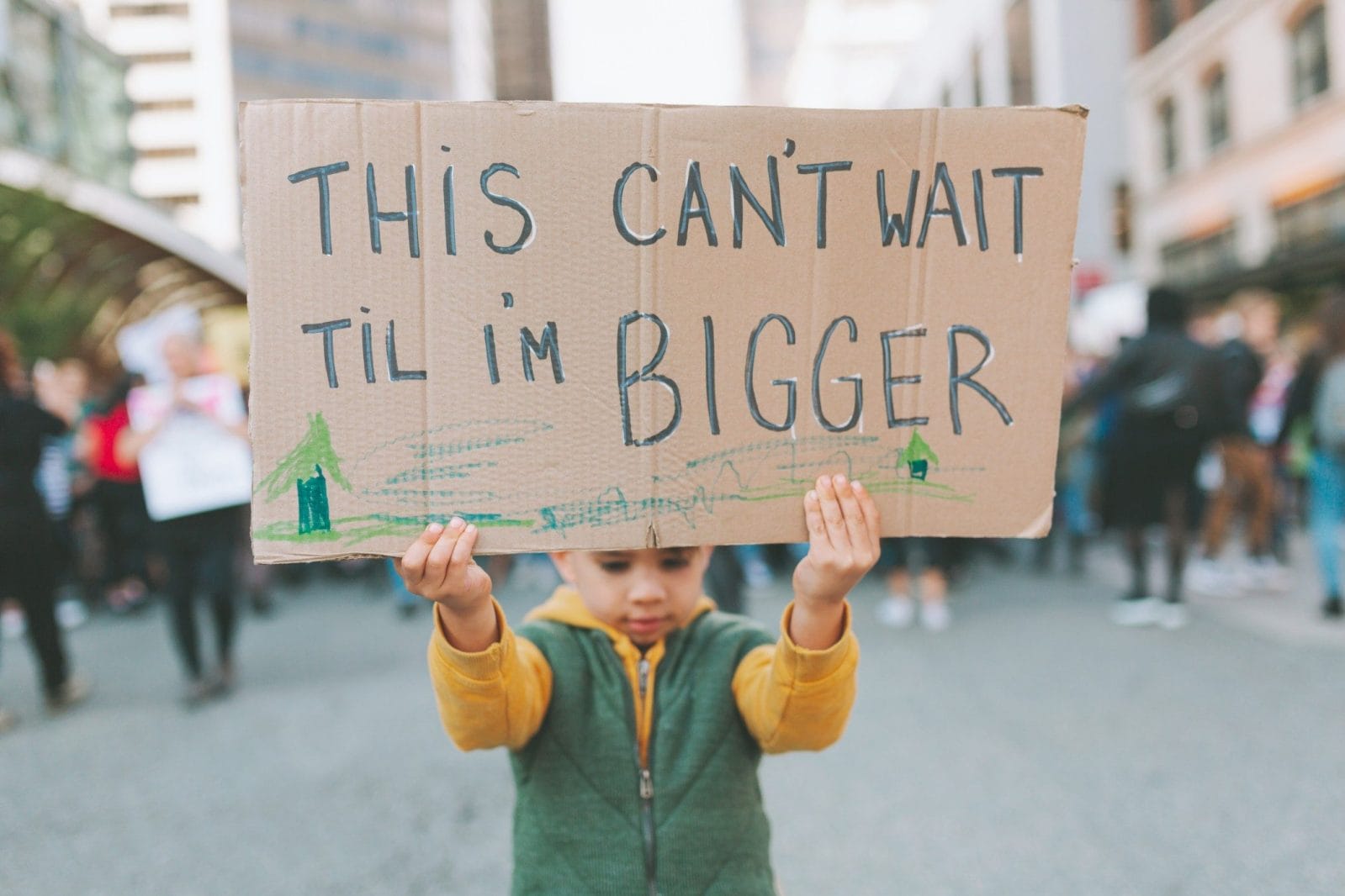 How to talk to kids about climate change and sustainability how to talk to kids about climate change - child holding a sign for earth day