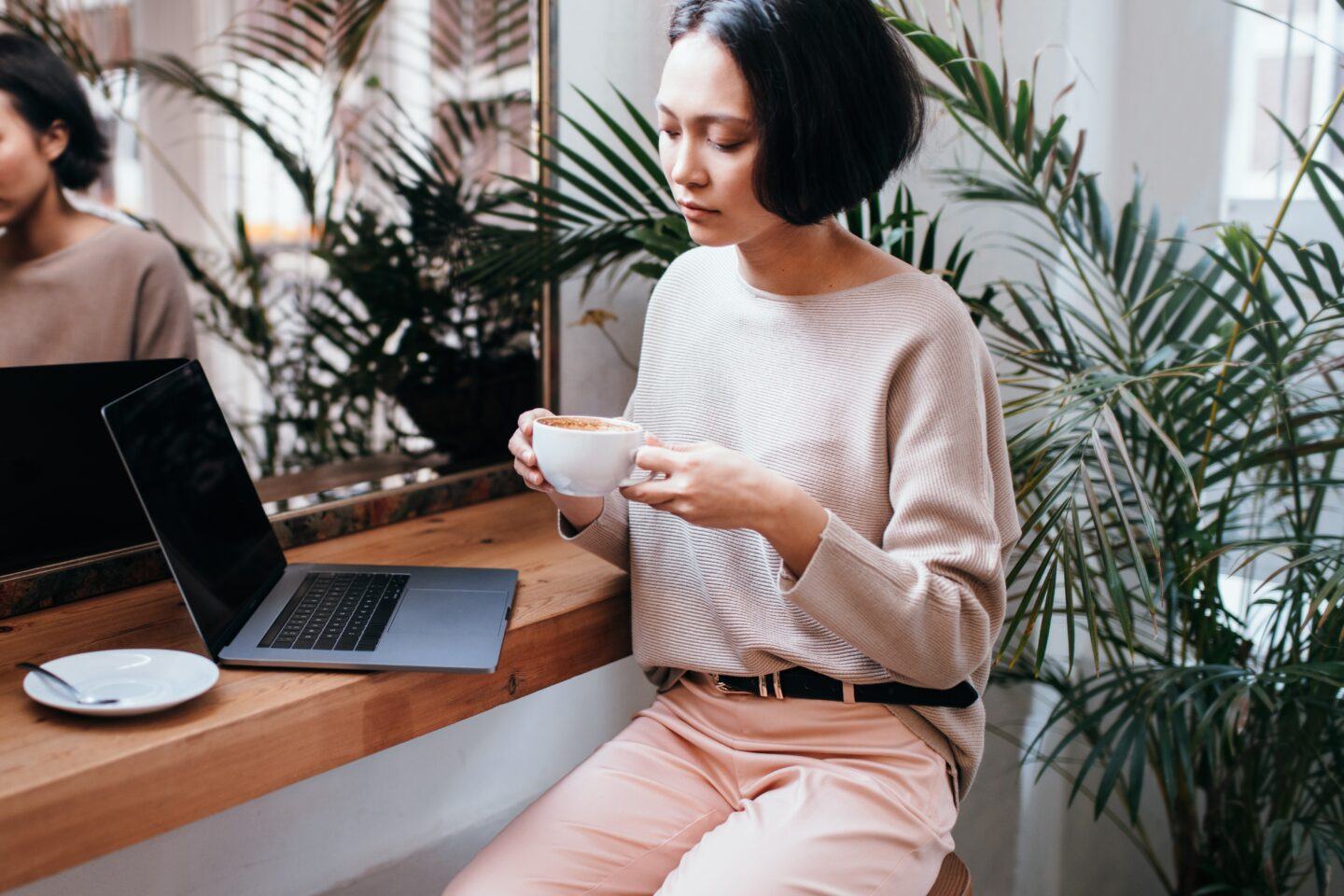 Your morning coffee could be making your anxiety worse woman drinking coffee at a cafe with laptop