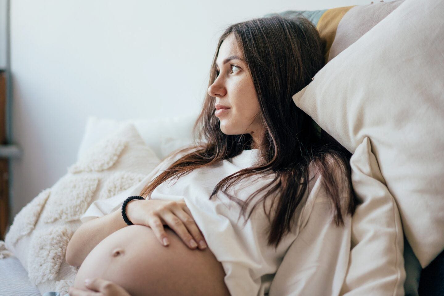 Pregnant women respond to Covid differently, depending on the sex of their baby pregnant woman lying on bed with hand on belly
