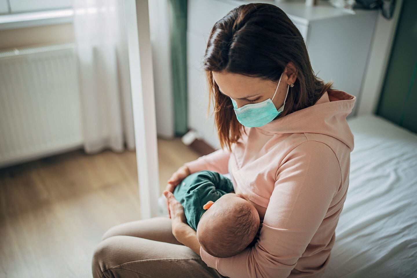 Yes, you can breastfeed with Covid, says new study Safe to breastfeed with Covid: Mother wearing face mask and breastfeeding baby at home