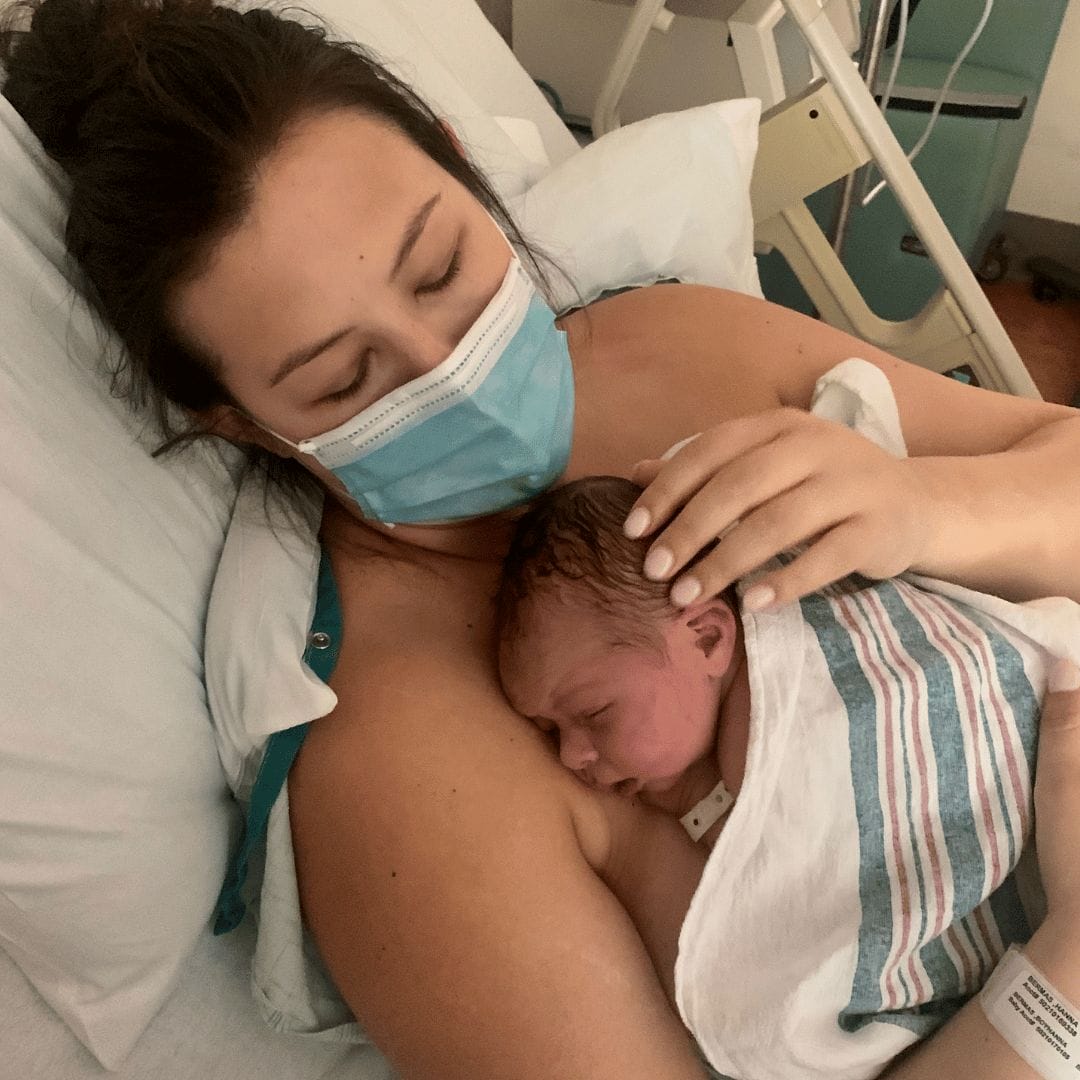 Hanna on PPD and PPA after undergoing an emergency hysterectomy after giving birth mom snuggling a baby in a hospital bed - essay on having an emergency hysterectomy after giving birth