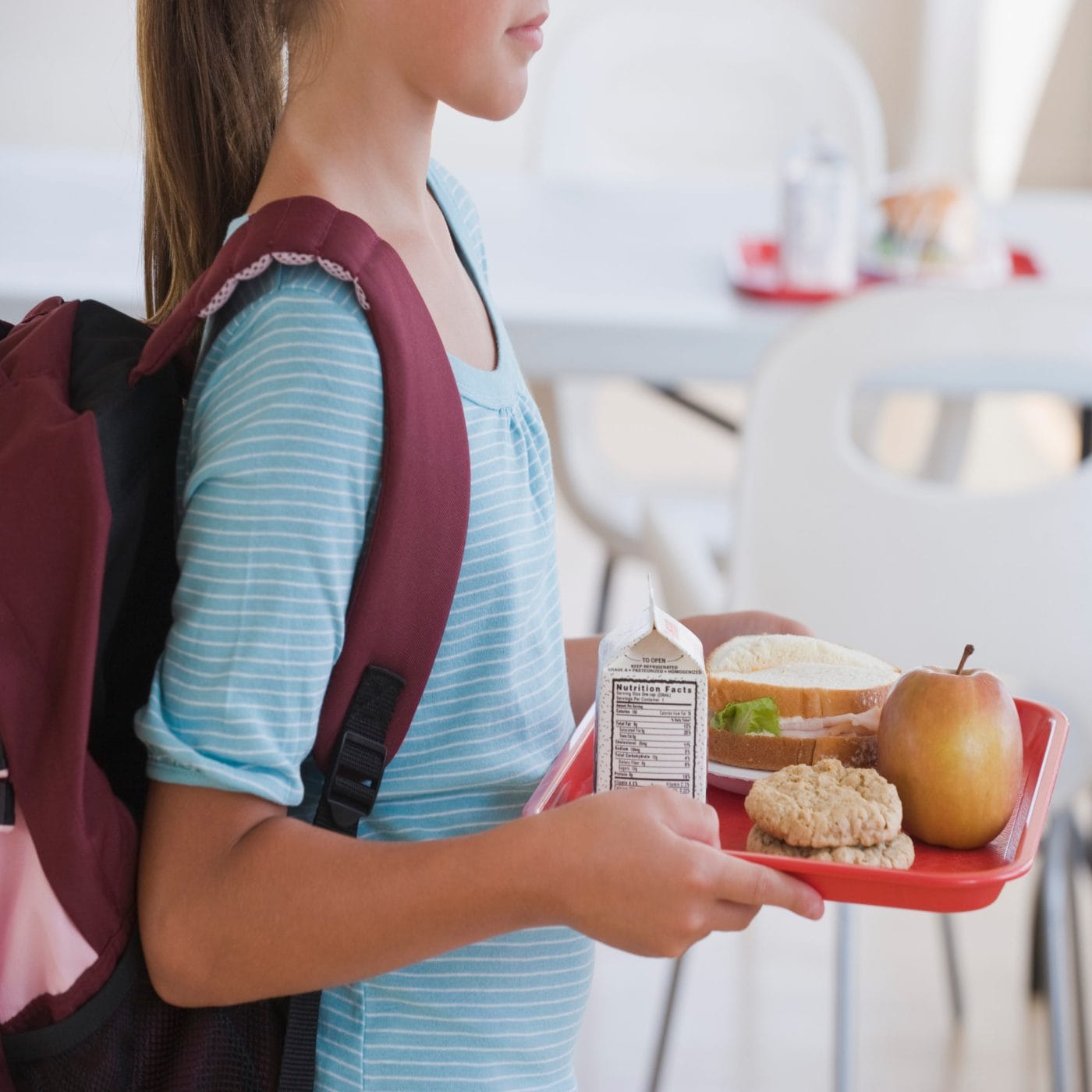 Plastic doesn’t belong in our kids’ school cafeterias. Here’s why Plastic free: Girl carrying lunch tray at school